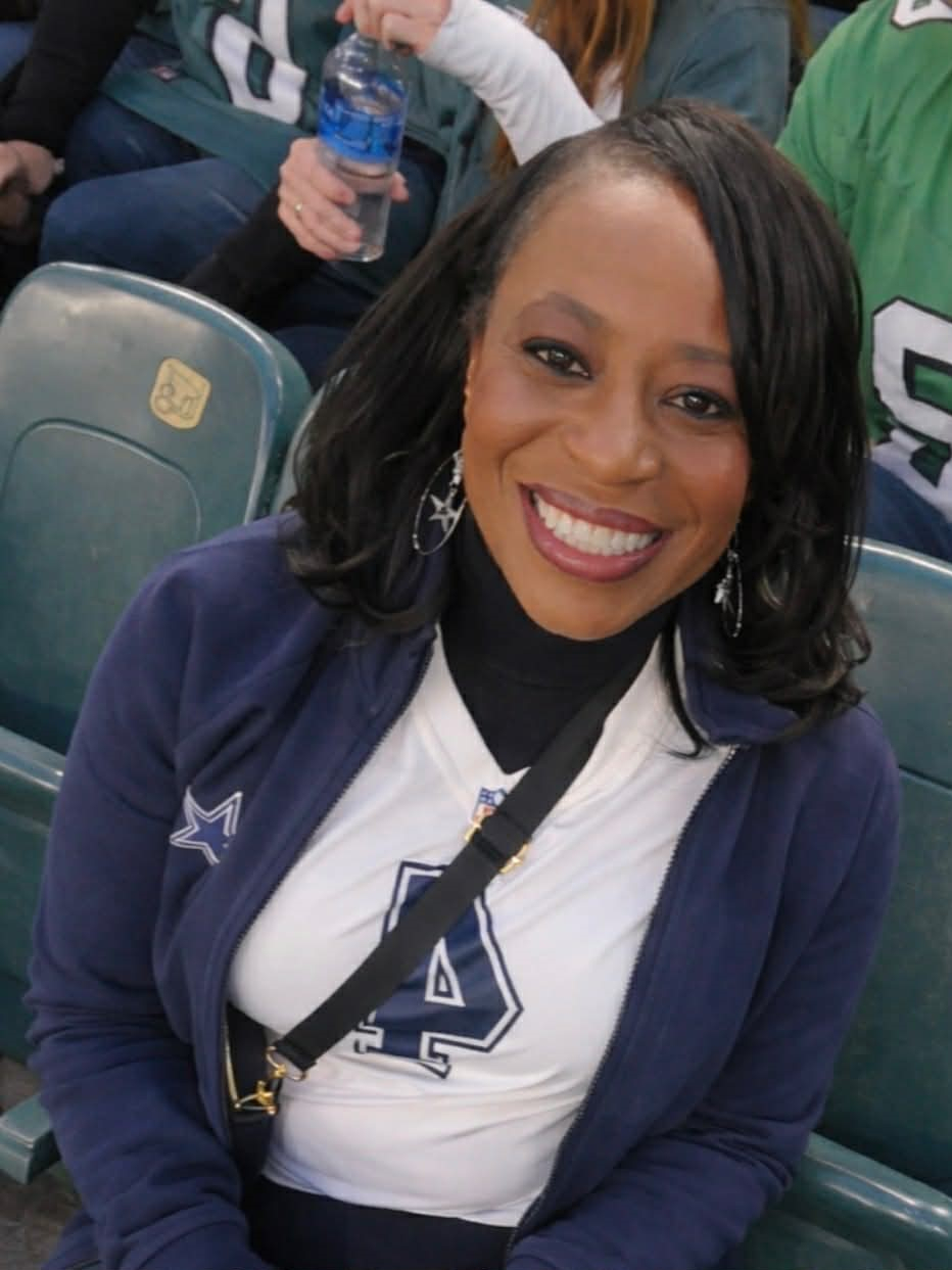 Pam Fisher, dressed in Dallas Cowboys gear, sitting in the stands at a Philadephia Eagles game