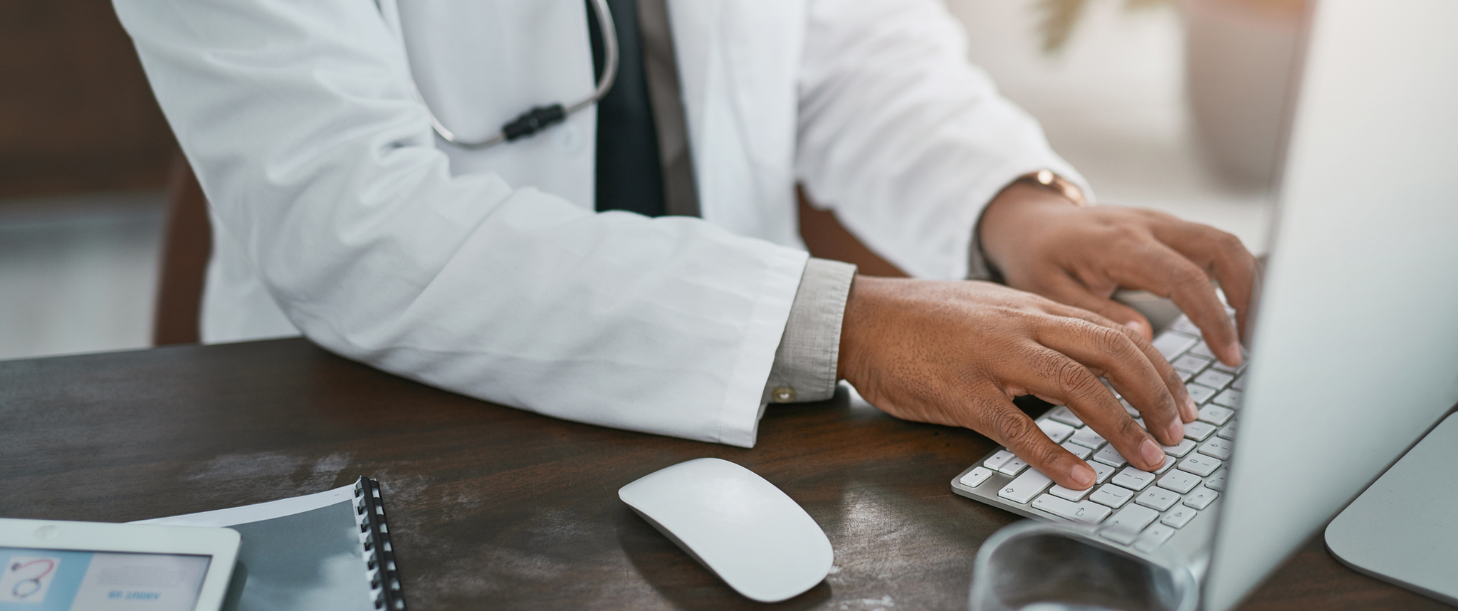 A doctor typing on a keyboard