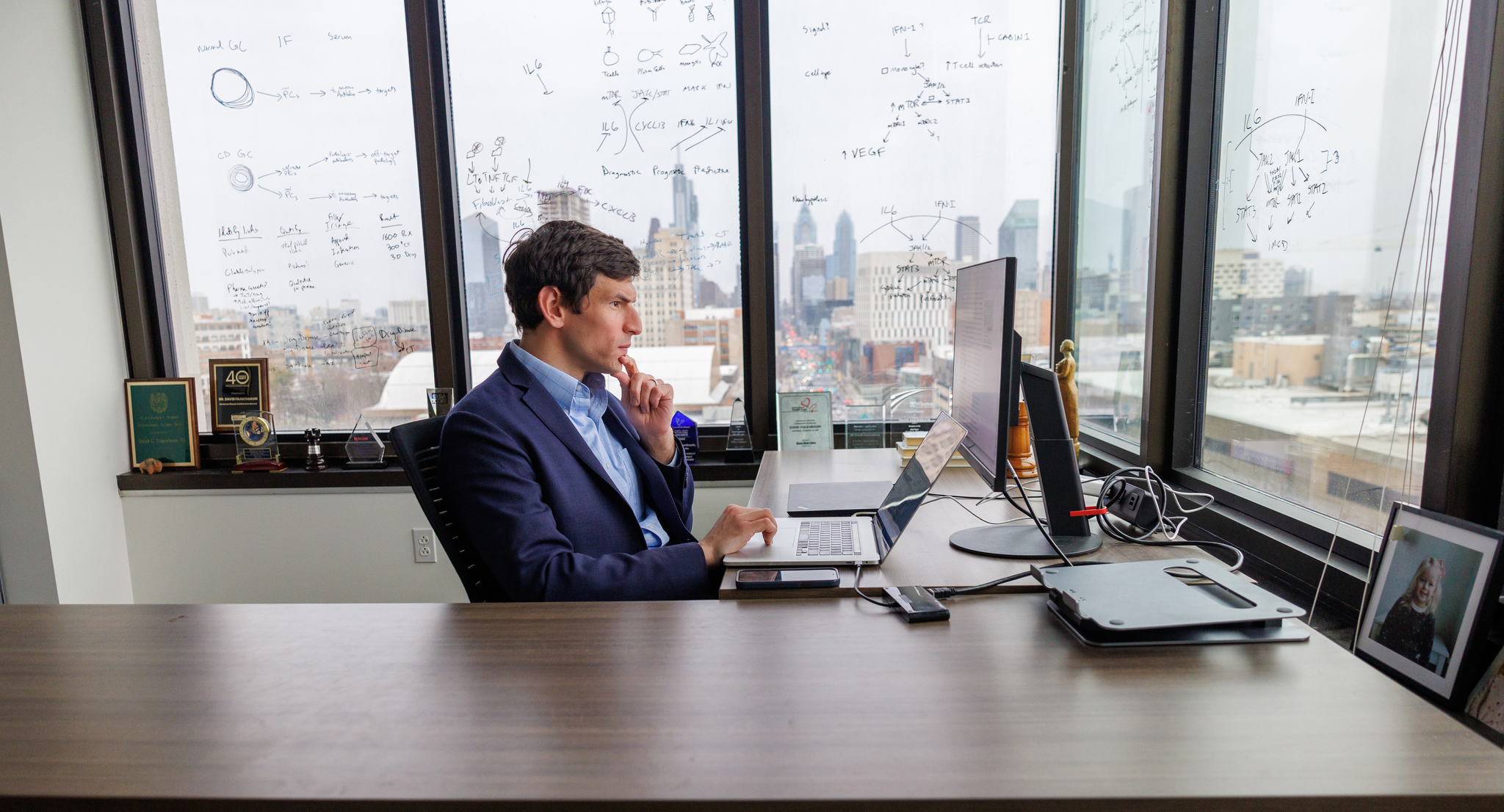 David Fajgenbaum, seen in profile seated at a desk with his hand thoughtfully on his chin