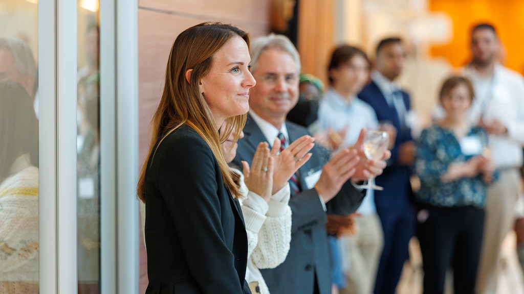 A woman smiling as people applaud