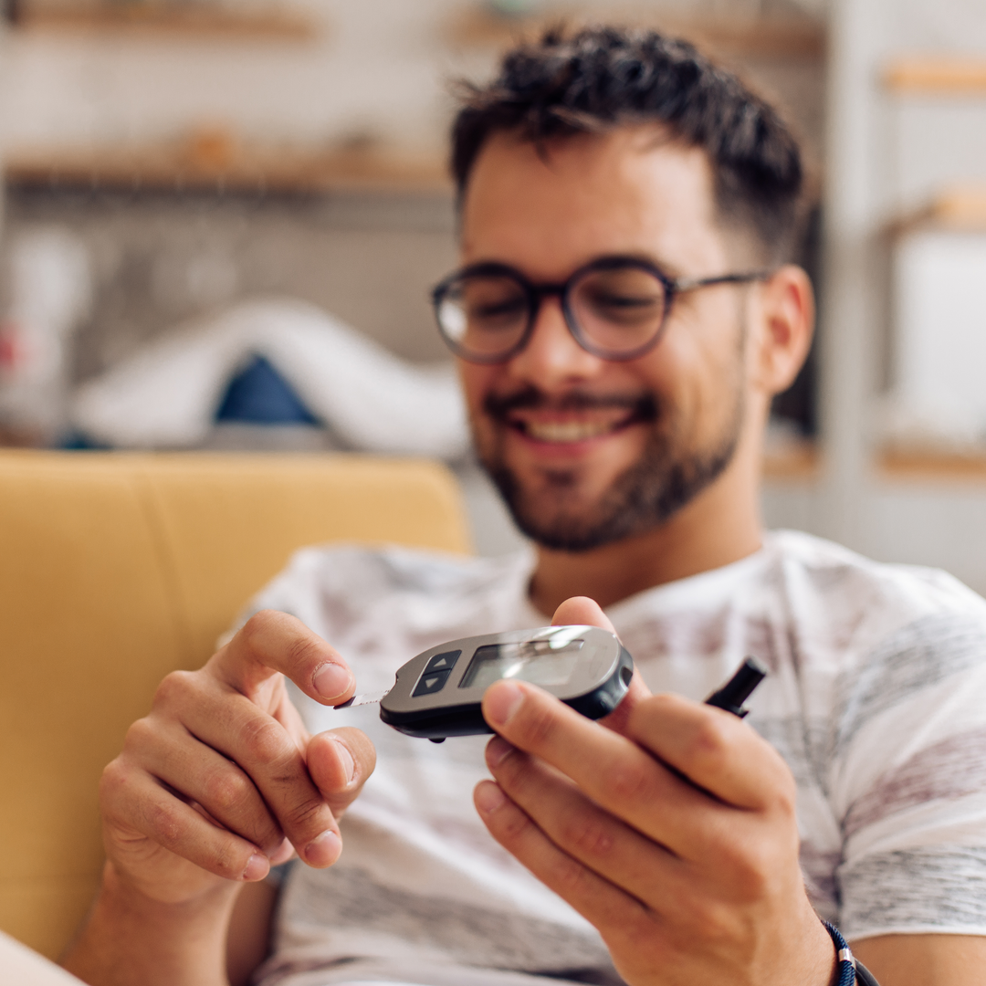 Young man measuring insulin level at home.