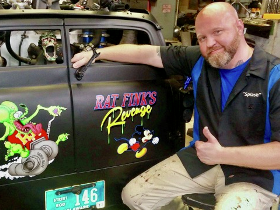 Mike making a thumbs-up sign, posing with painted-on car door
