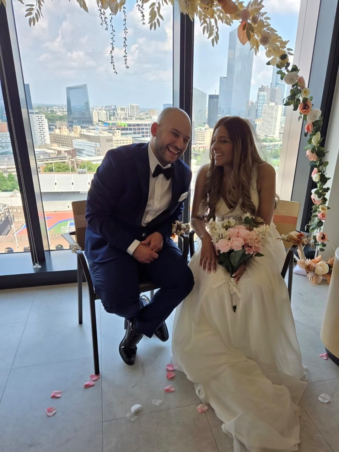 Patient Alexis Rodriguez and her new husband, Jeffrey Striddels, sit in front of the flower arch the oncology nurses made for their wedding