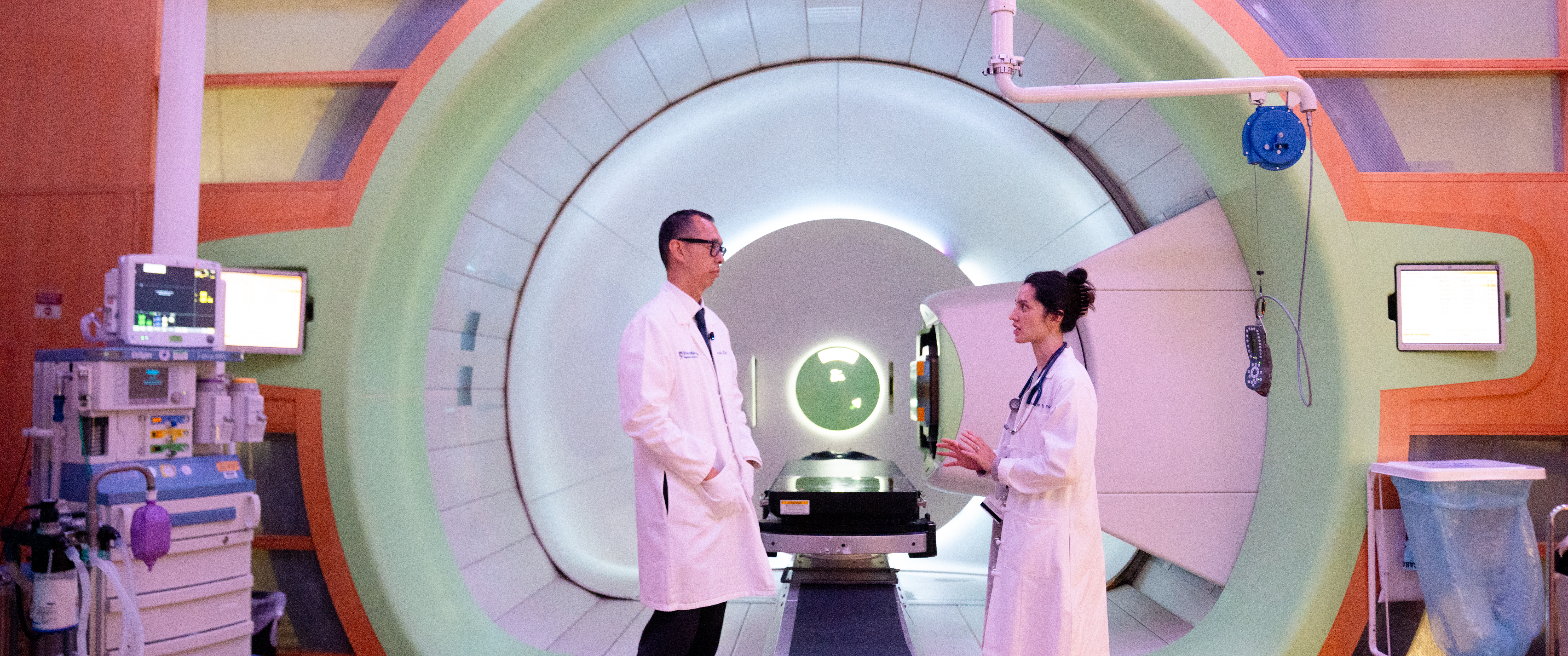 Alexander Lin and an advanced practice provider standing in front of a proton treatment room