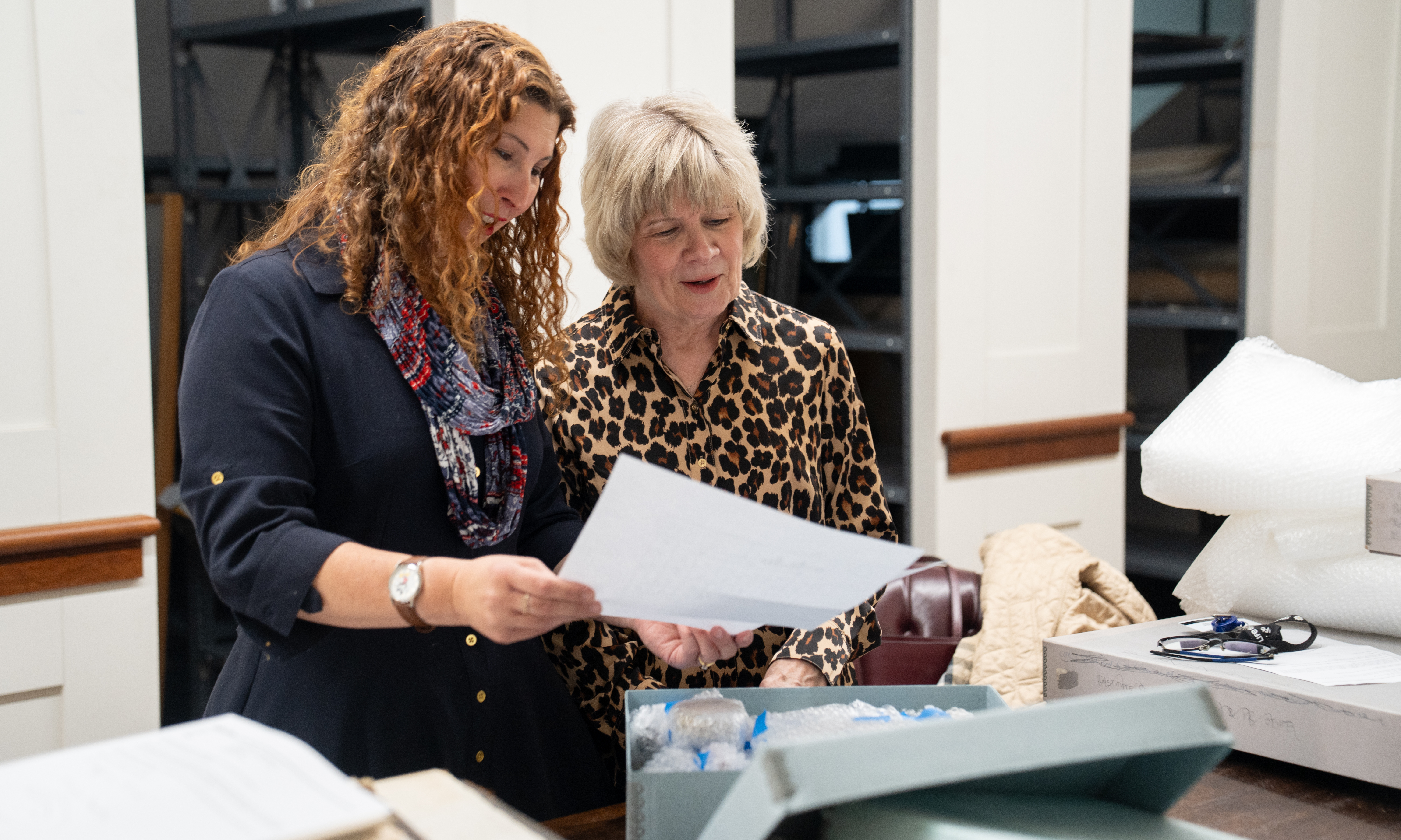 Stacey Peeples and archives volunteer Kathleen Finnegan, looking at the contents of a box