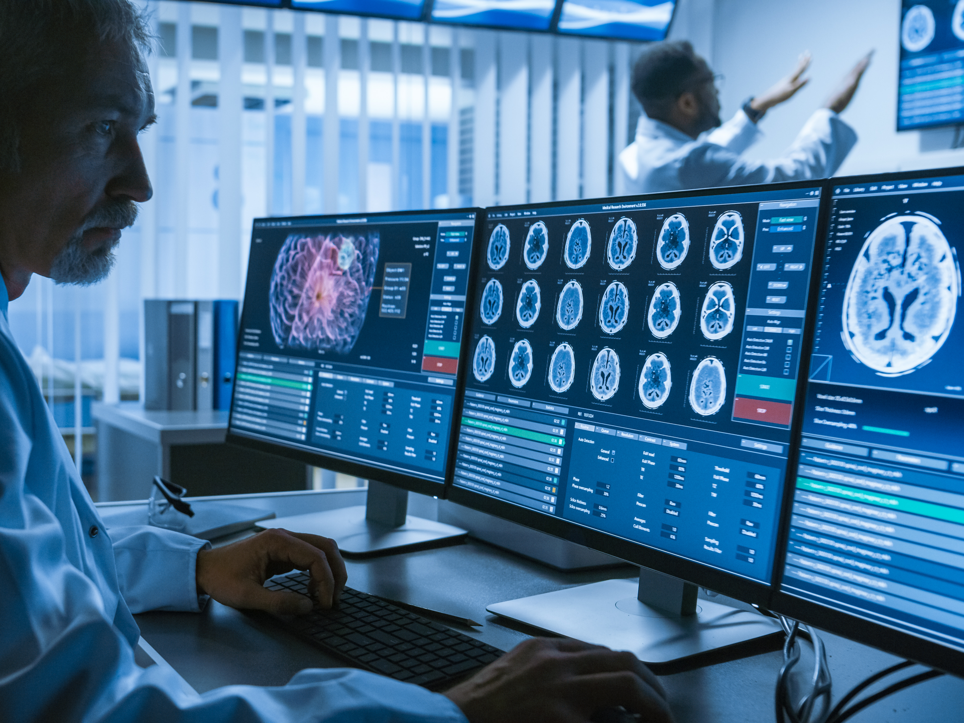 Over the shoulder shot of senior medical scientist working with CT brain scan images 