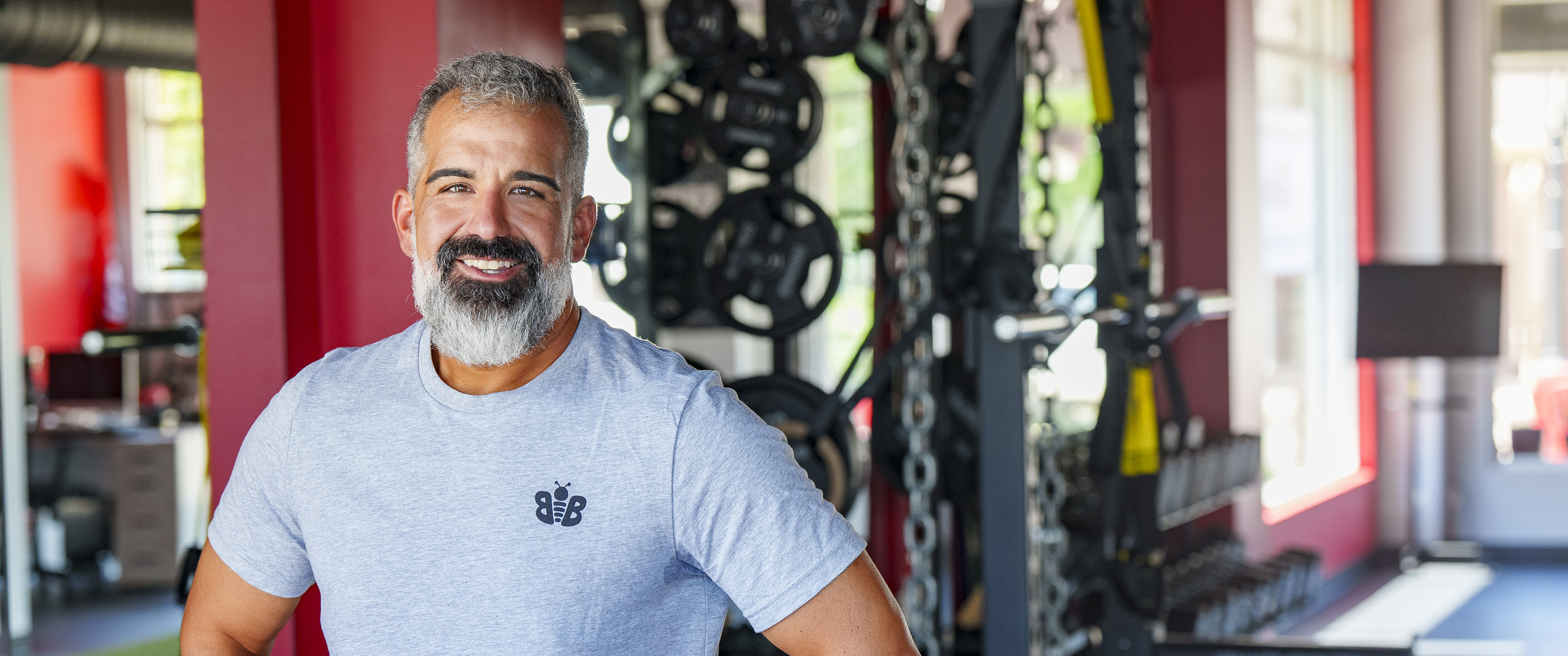 Rob DiMedio standing in front of weights and strength training equipment at the gym 