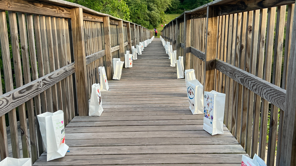 Luminary bags on a wooden bridge at Camp Erin