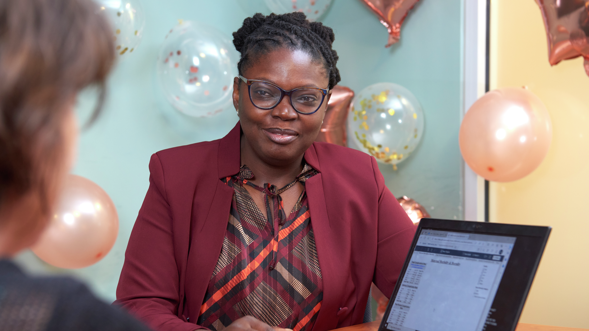 Abike James sits next to a laptop displaying data tables