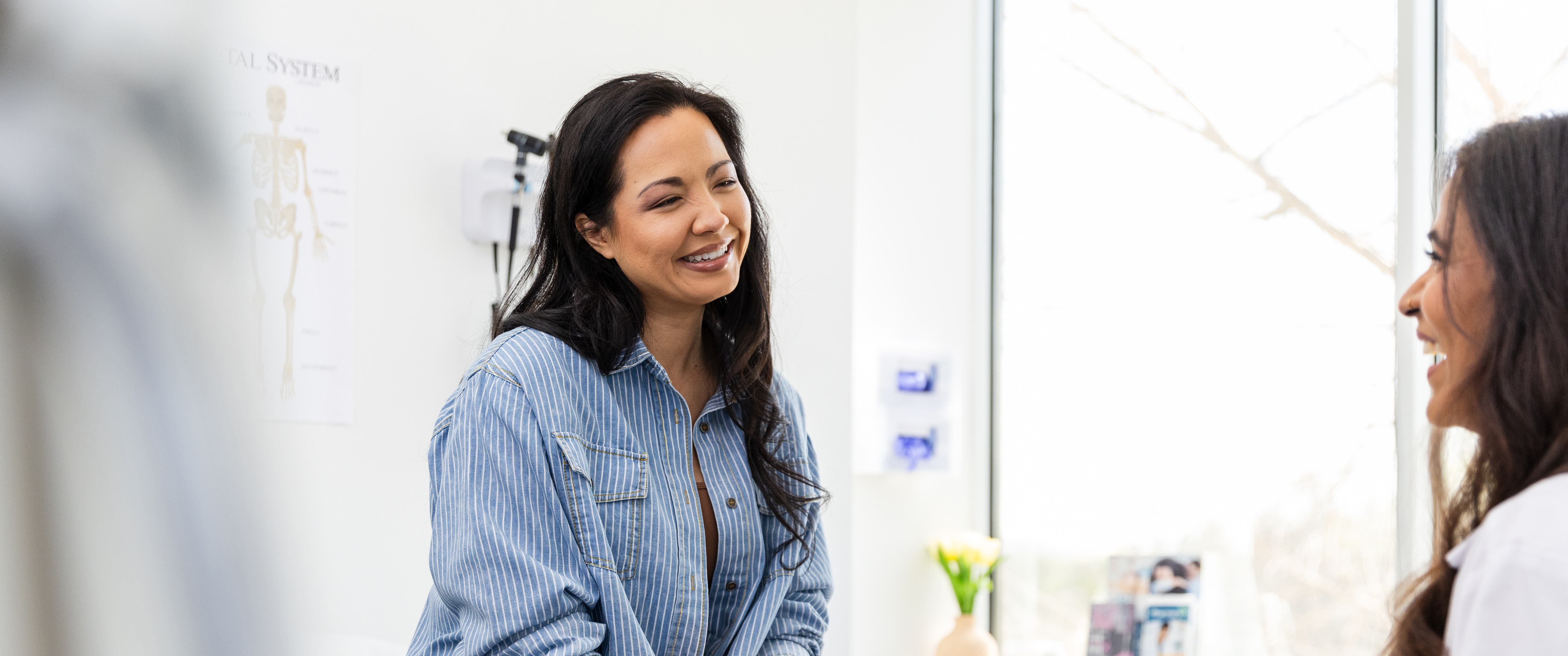 Patient and doctor laughing in exam room during appointment
