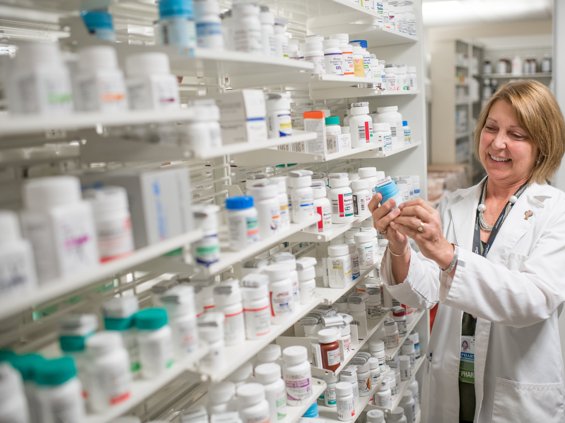 Pharmacist, Donna Weist, looks at pill bottle at the convenience pharmacy in Lancaster General Hospital