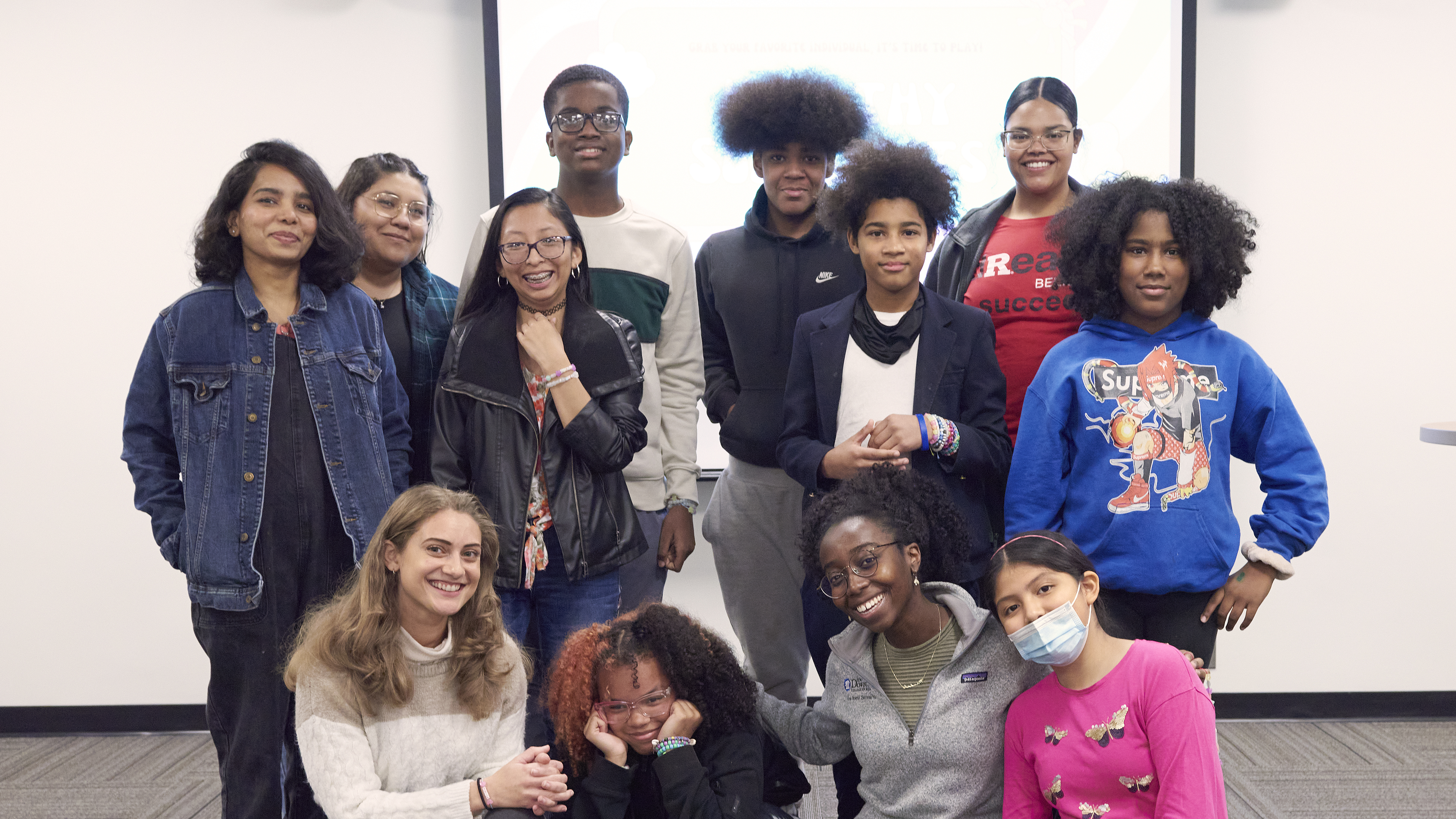 Group photo of preteen and teenage students with Liz Ramos and Michel Ntiri