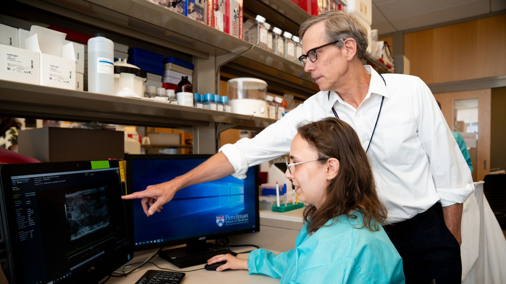 Robert H. Vonderheide, MD, DPhil, points to a screen where a member of his lab is looking at an image of cancer cells