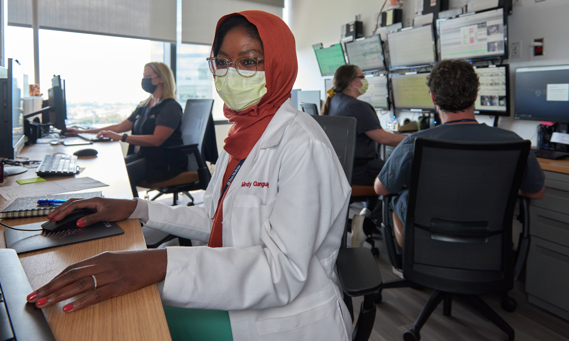 Mindy Ganguly, a neurology resident, sits at a long desk in a control room