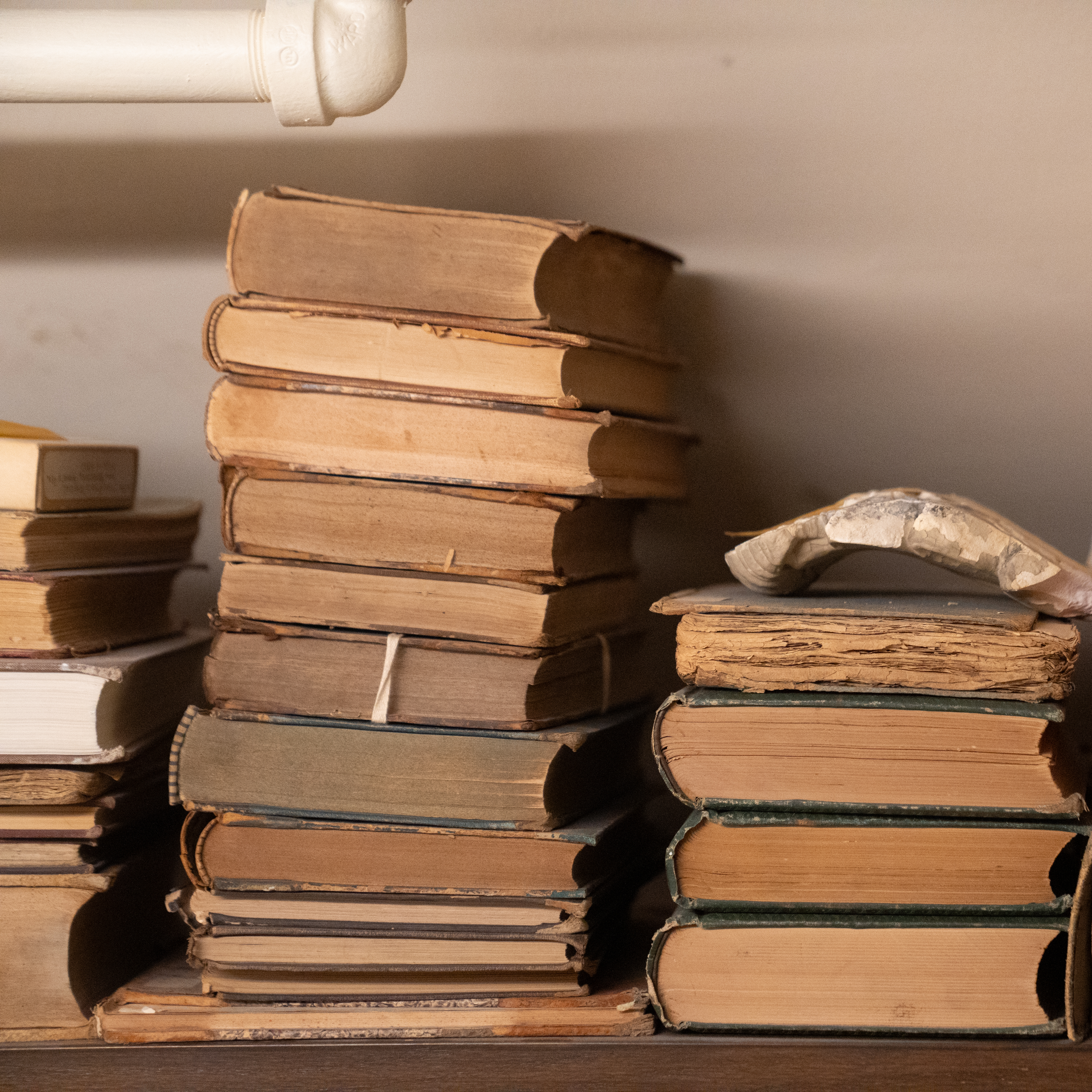 Stacks of old books on a shelf in the Pennsylvania Hospital archives