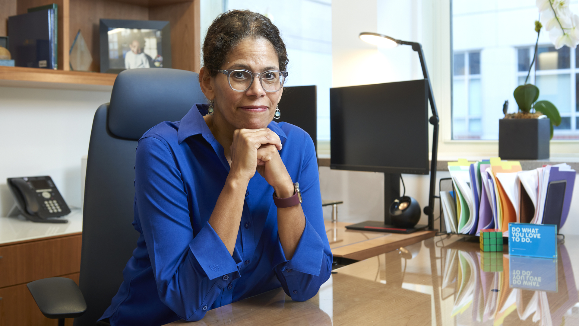 Elizabeth Howell, MD, seated at her desk with a slight smile, her head leaning on her hands