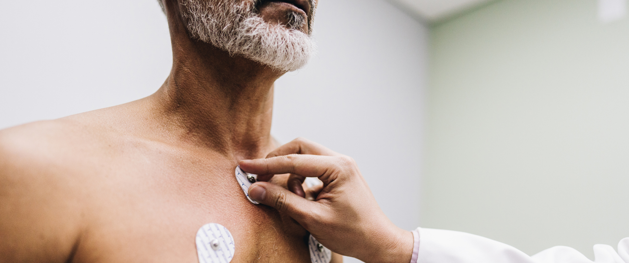 A doctor places electrodes on a man's chest