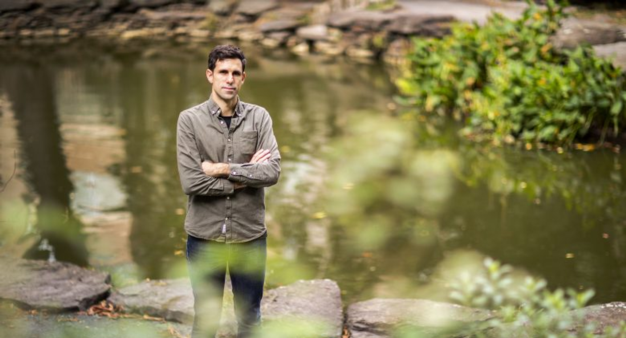Portrait of Cesar de la Fuente standing in front of a pond