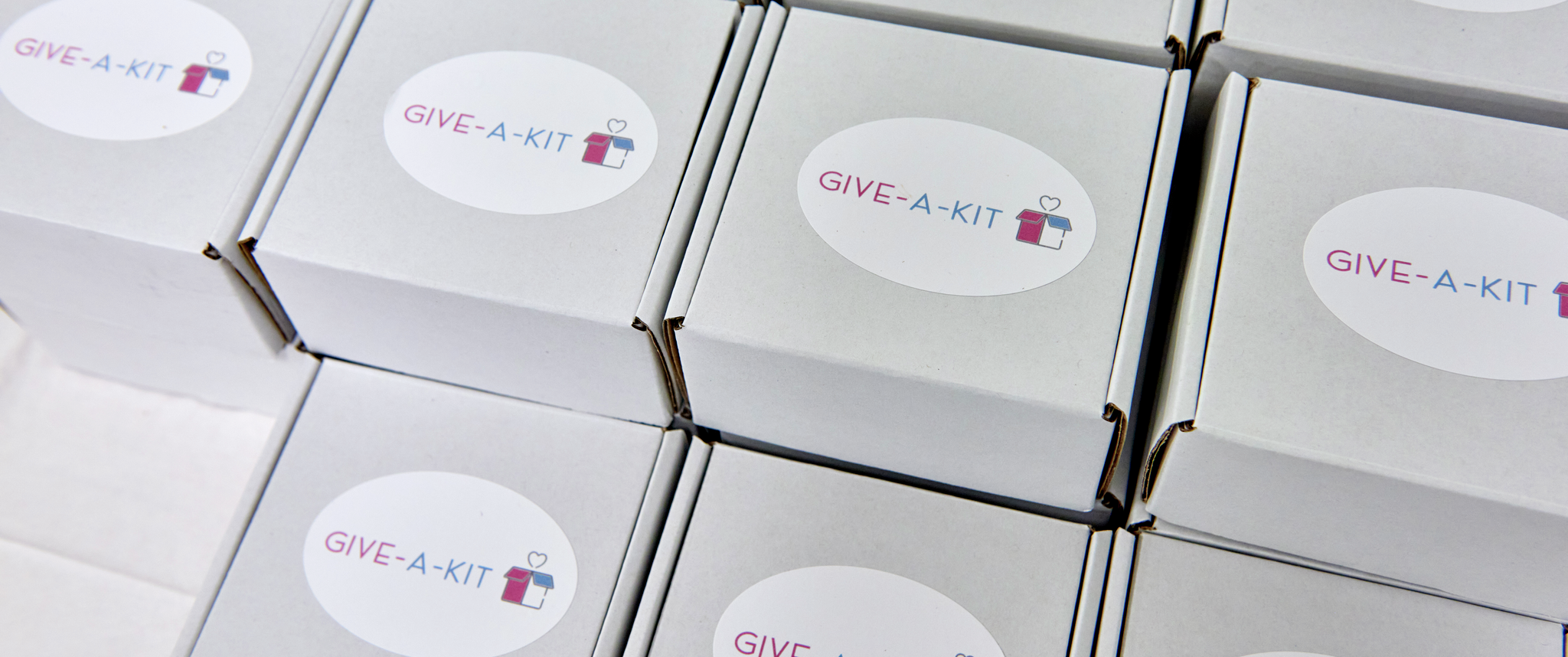 An array of small cardboard boxes with a Give-A-Kit sticker label
