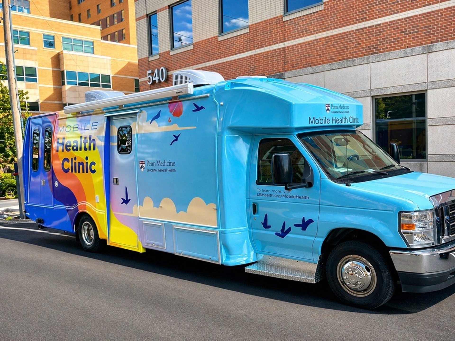 Bright blue van with a rainbow and cloud design, and Penn Medicine Lancaster General Health mobile health clinic written on the side.