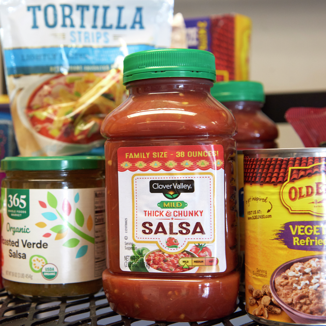 A shelf full of packaged Mexican foods including salsa and beans