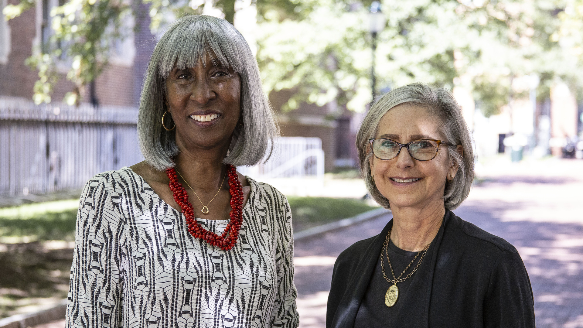 A portrait of Carol Benenson Perloff with Jayne Henderson Brown, standing outdoors