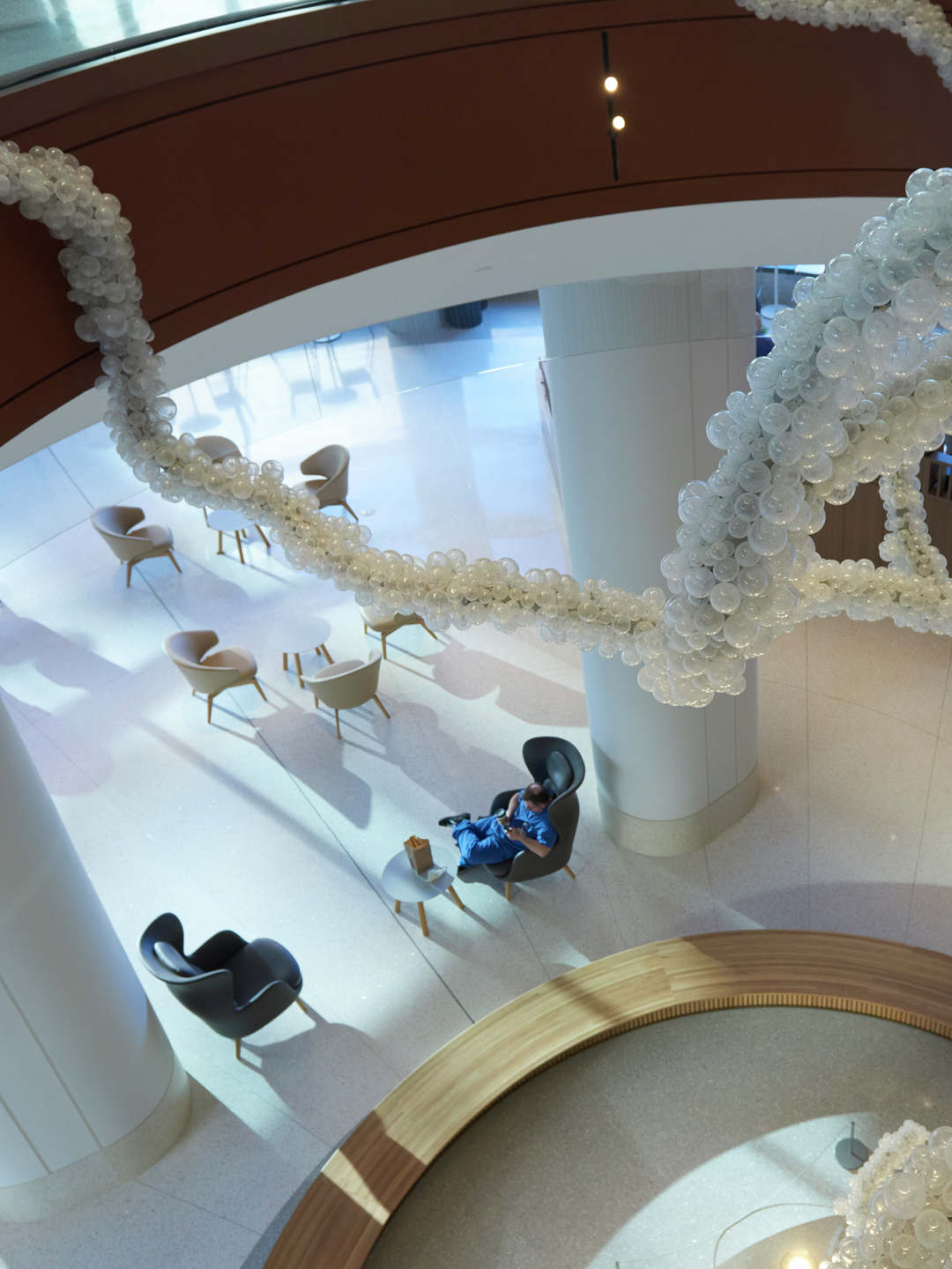 The Pavilion ground floor lobby as seen through an oculus, looking down through the glass-ball tree-like sculpture