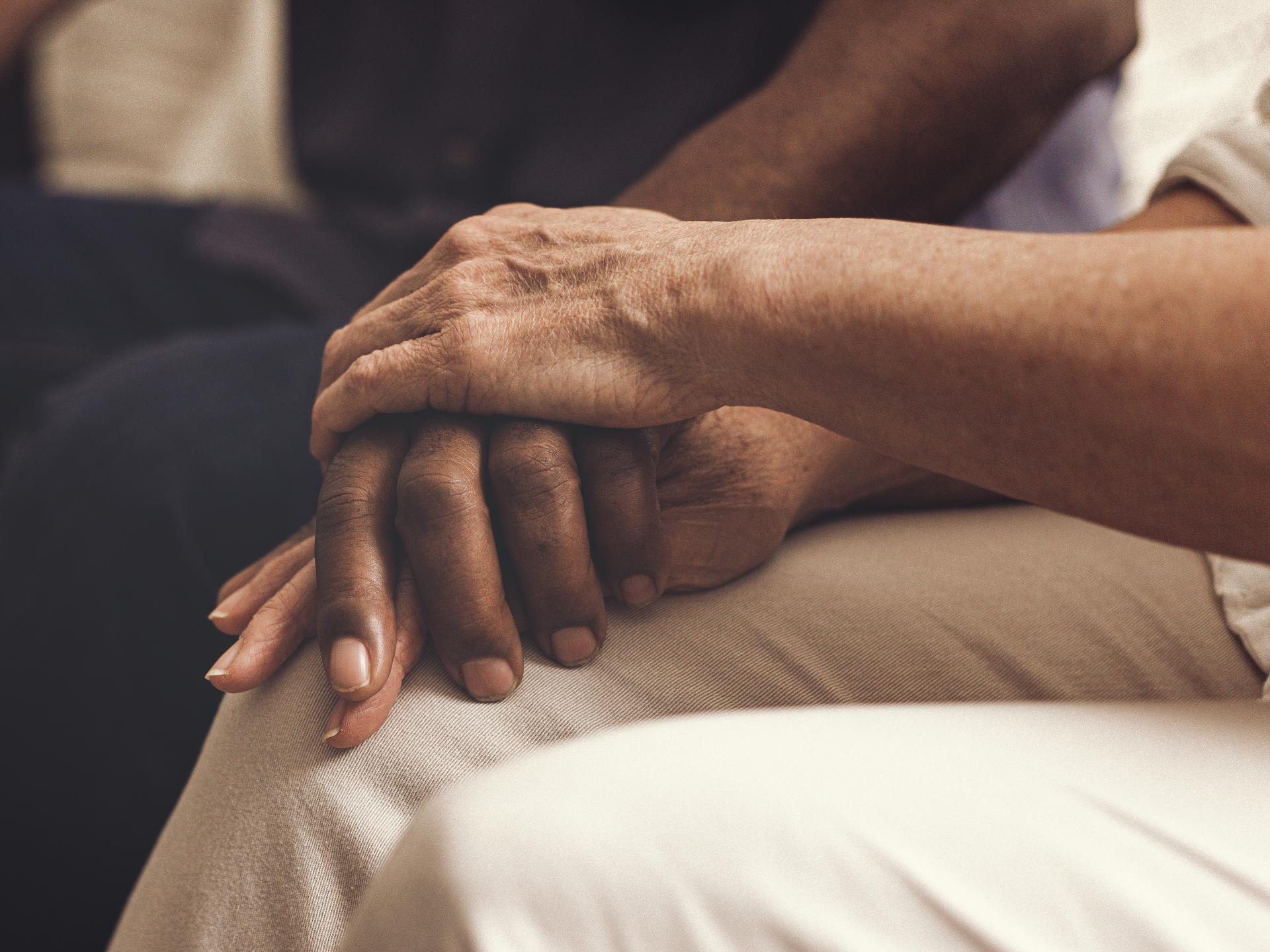 A multiracial couple comforting each other.