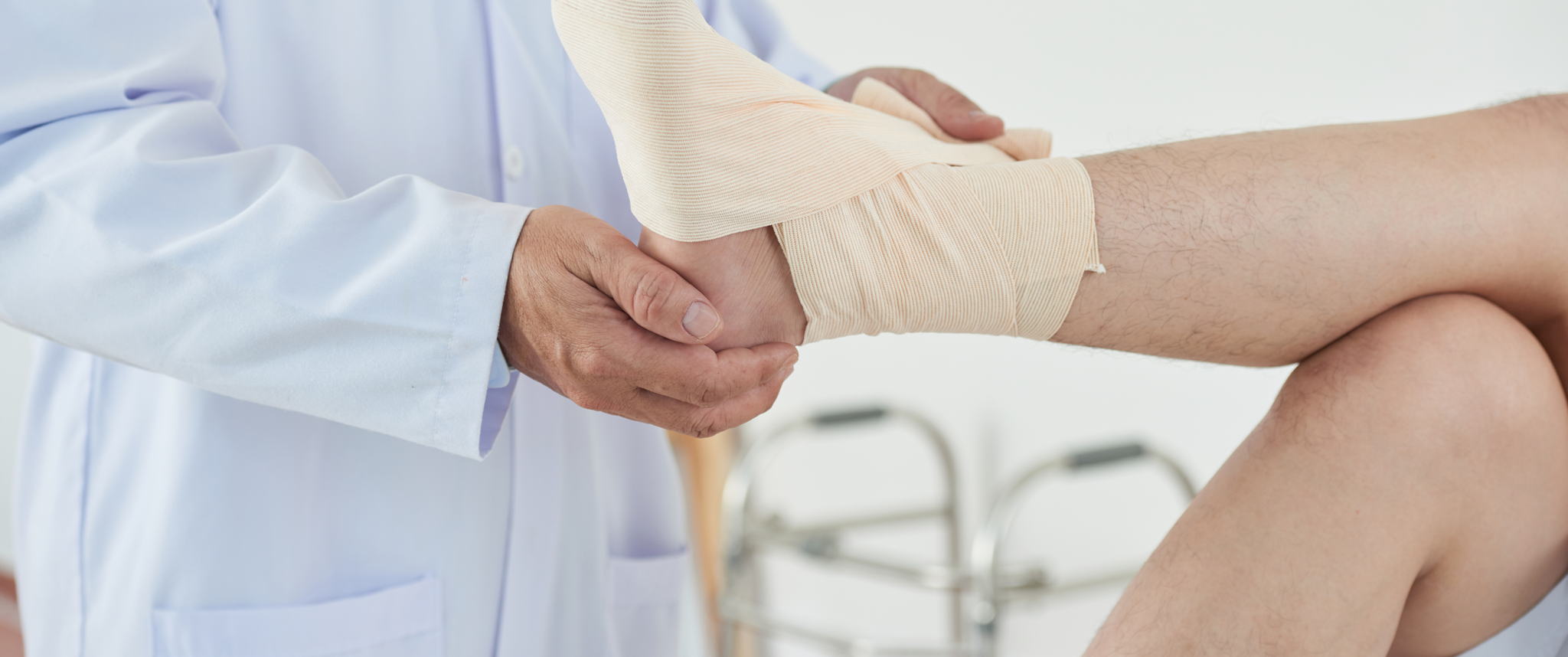 A doctor bandaging foot of patient