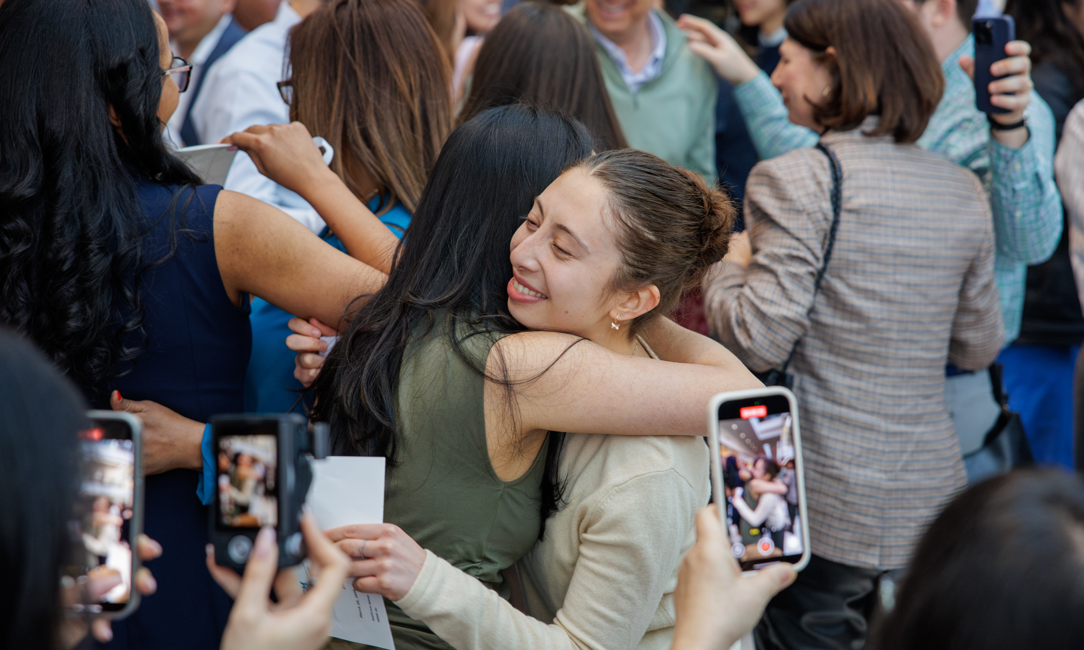 Two women embrace among a crowd of smiling and happy people at Penn’s Match Day 2026