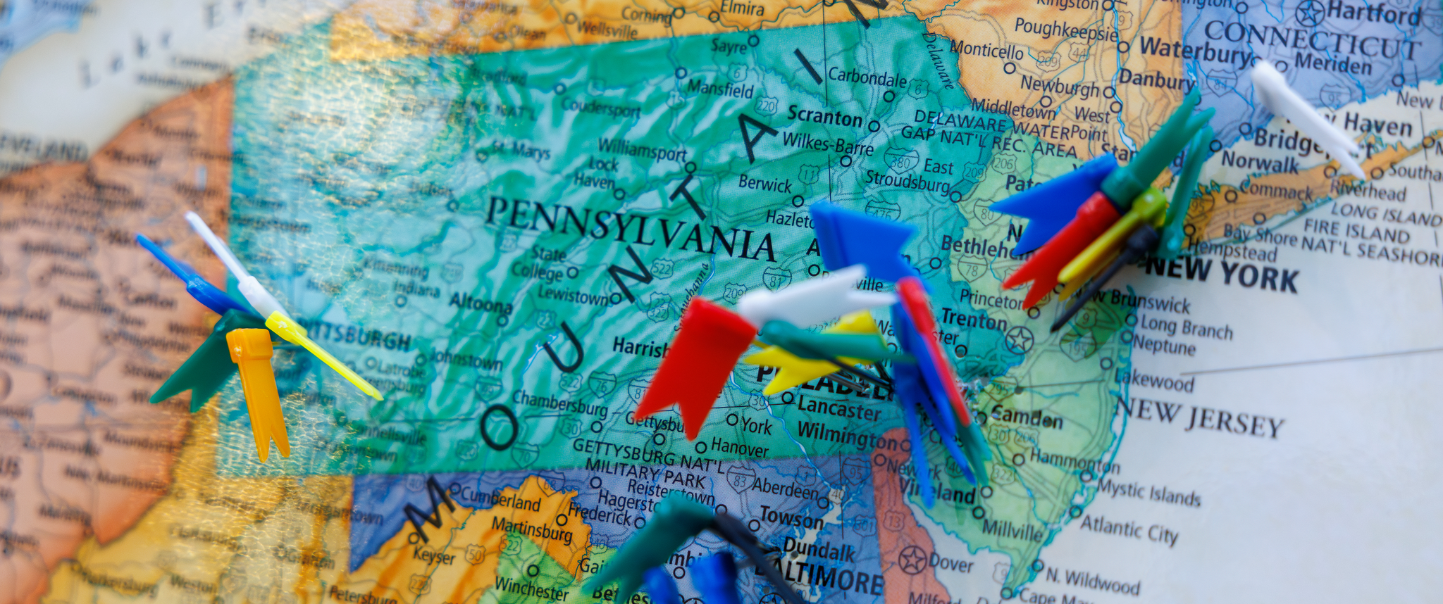 A map of Pennsylvania and surrounding states with numerous colorful flag pins inserted