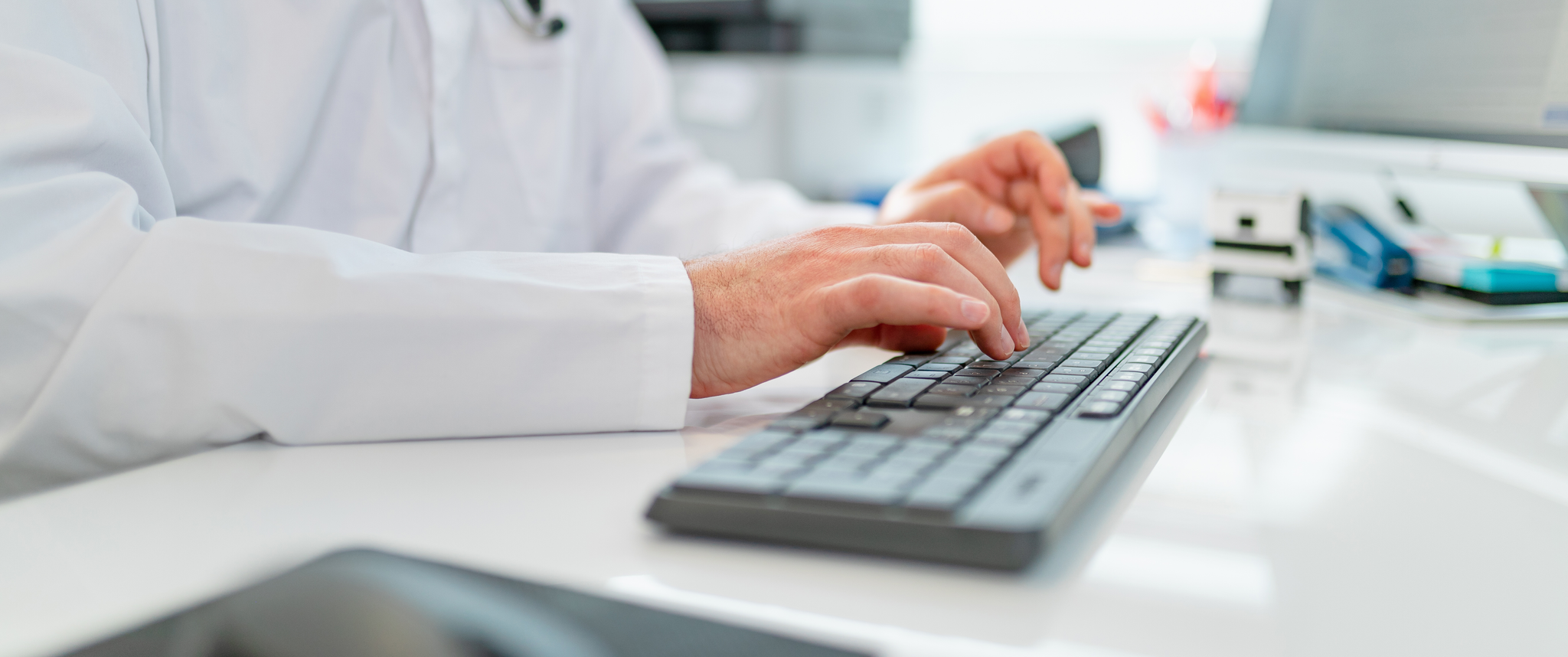 A doctor types on their computer keyboard