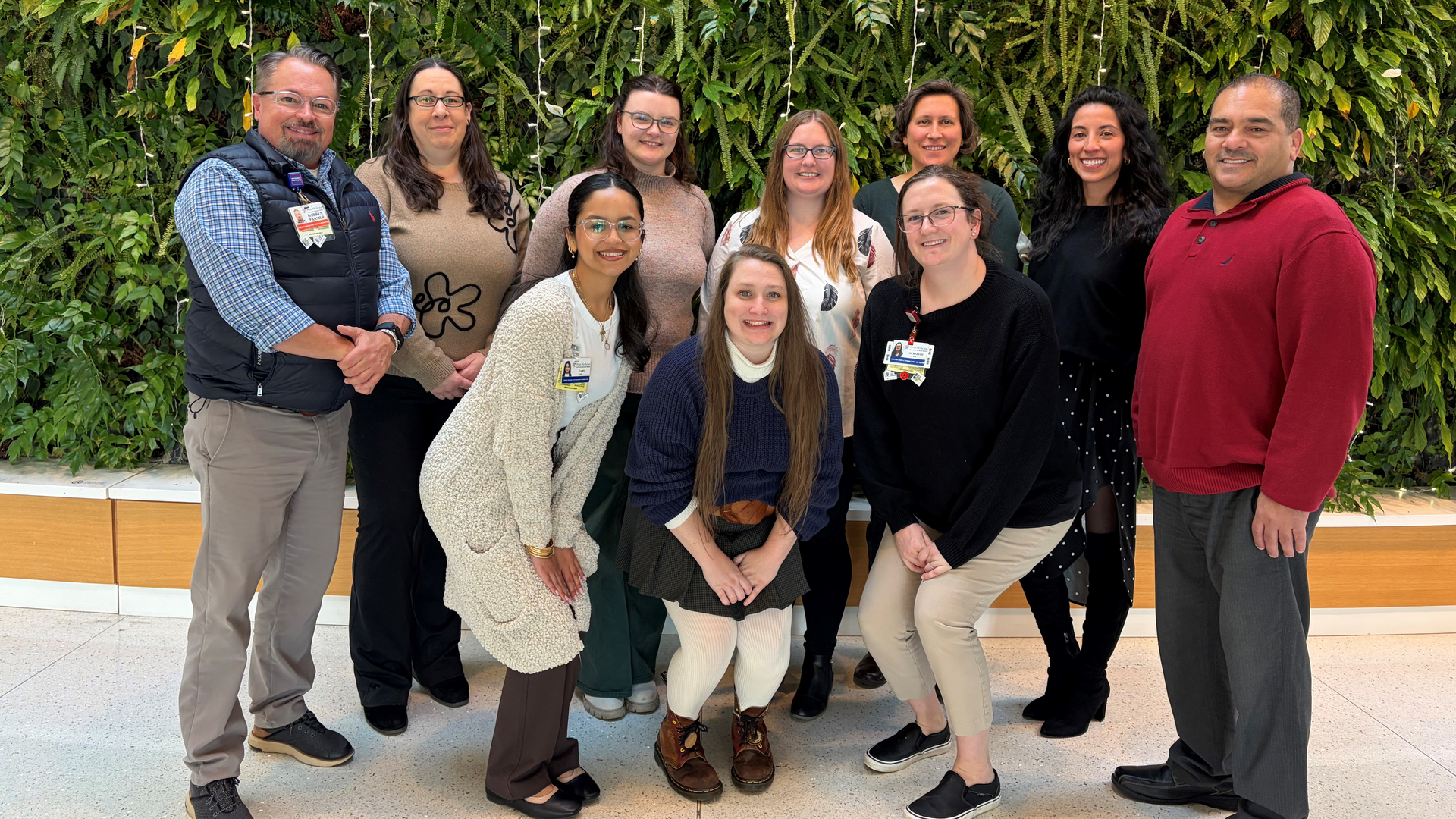 The Lead-Free Families team poses in front of a wall covered in greenery