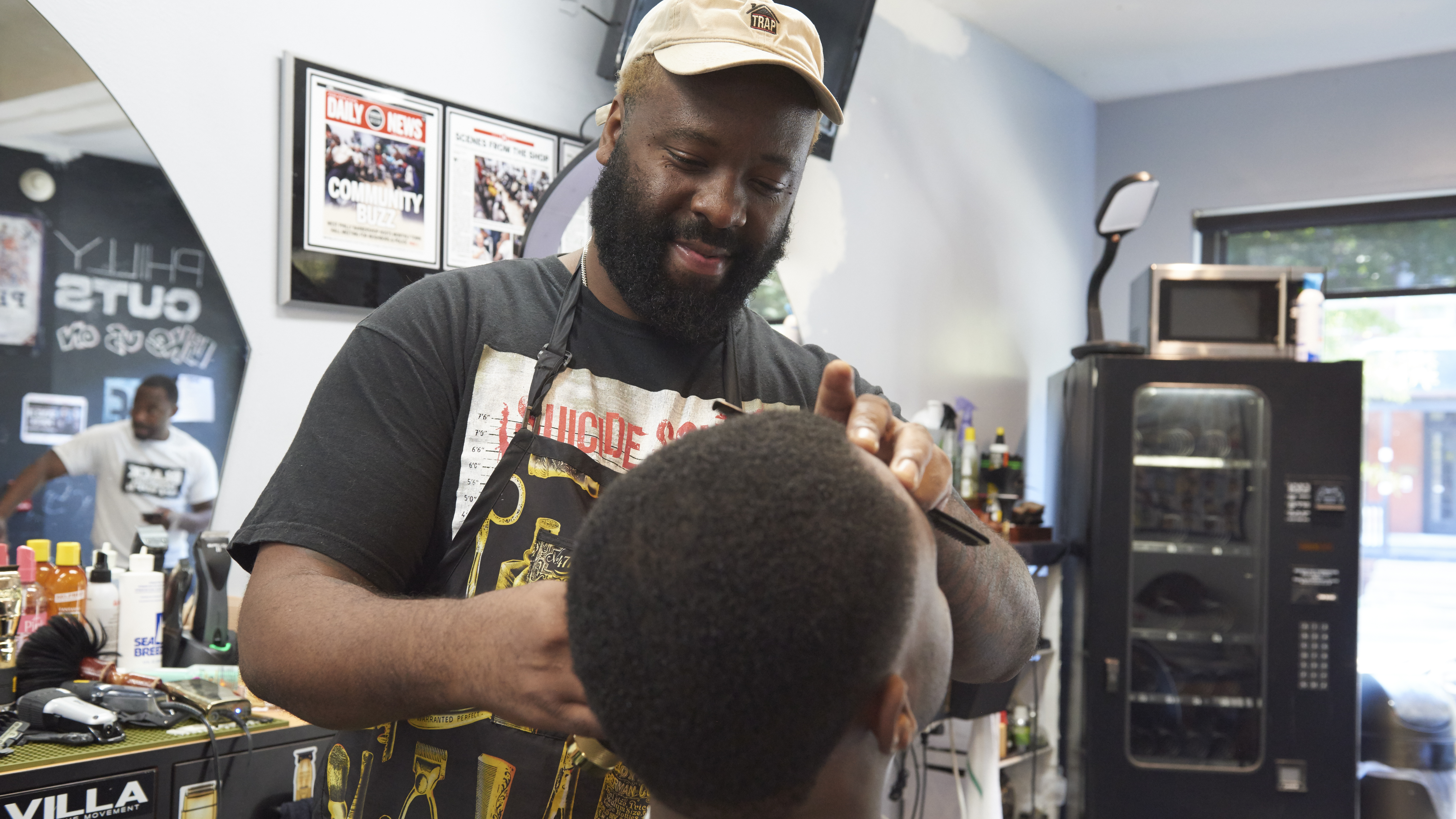 Maurice Anderson trims a patron’s hair at Philly Cuts