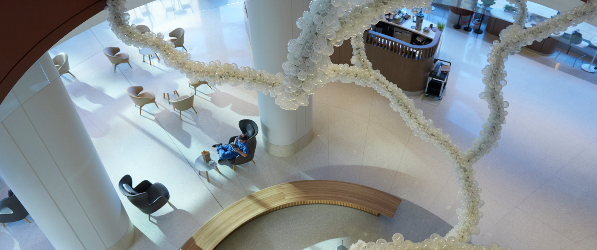 The Pavilion ground floor lobby as seen through an oculus, looking down through the glass-ball tree-like sculpture