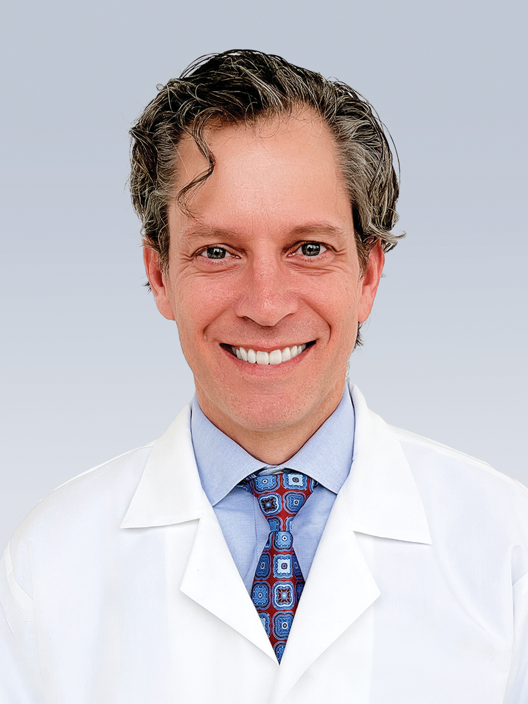 Headshot of Peter Eby, MD, in a white coat