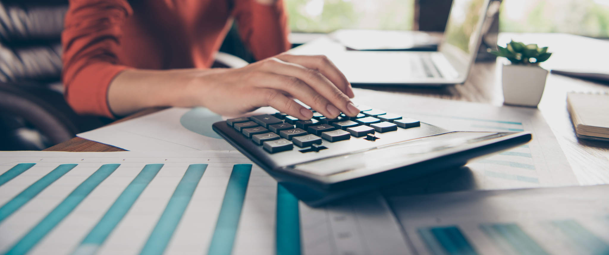 Cropped shot of woman using calculator, managing finances