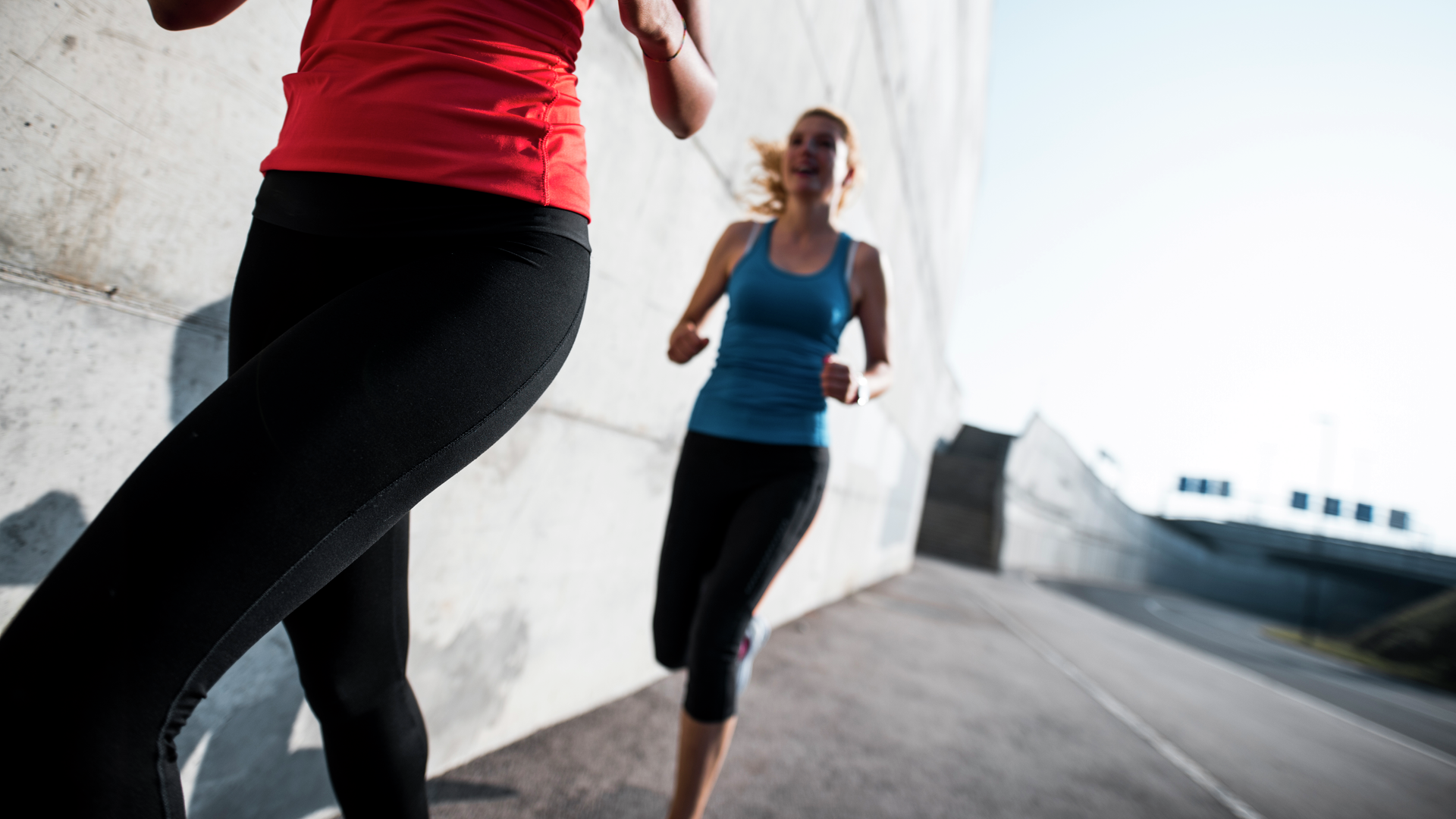 Close up of two friends running together in the morning