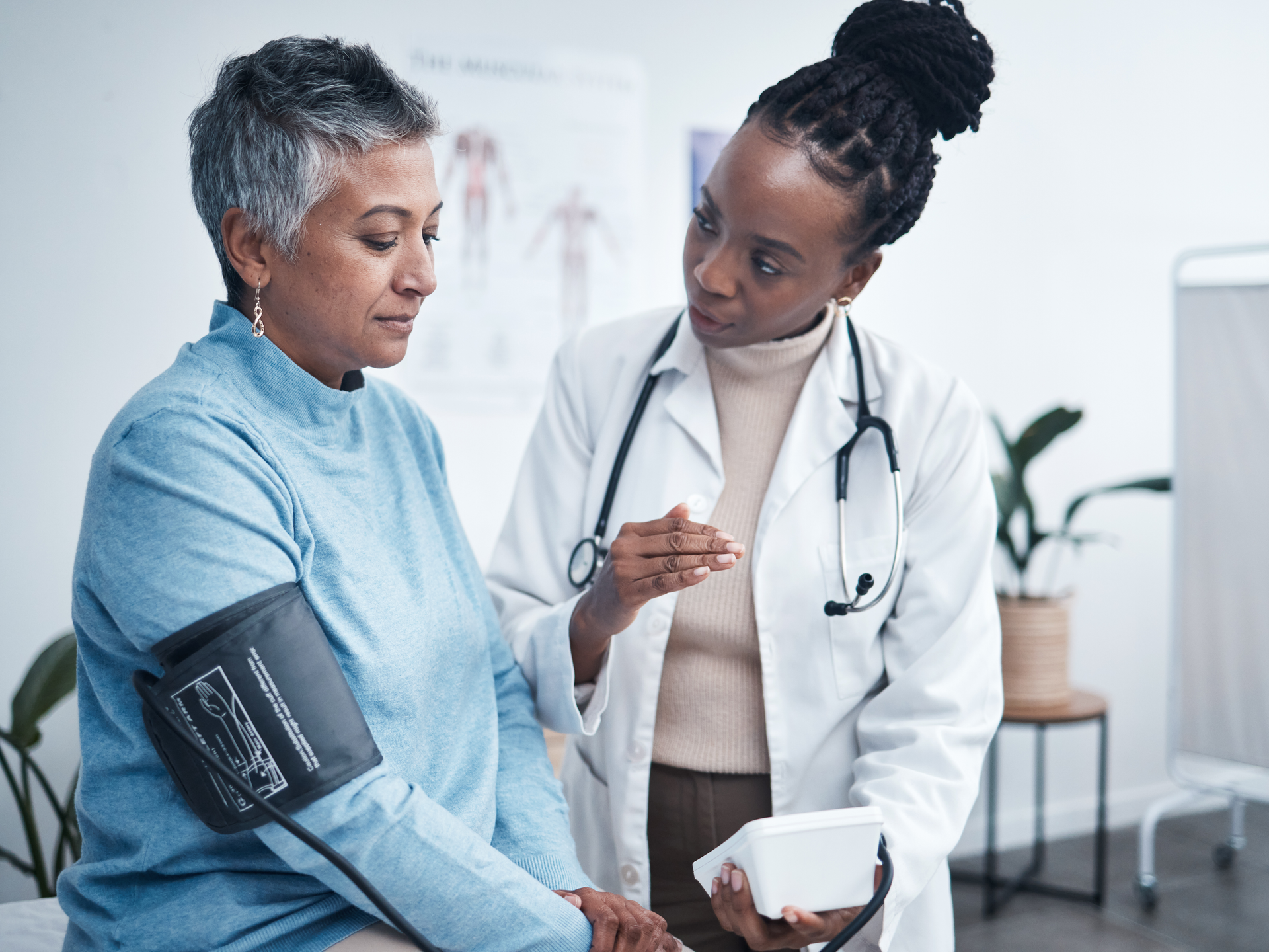 Doctor and senior patient with blood pressure reading