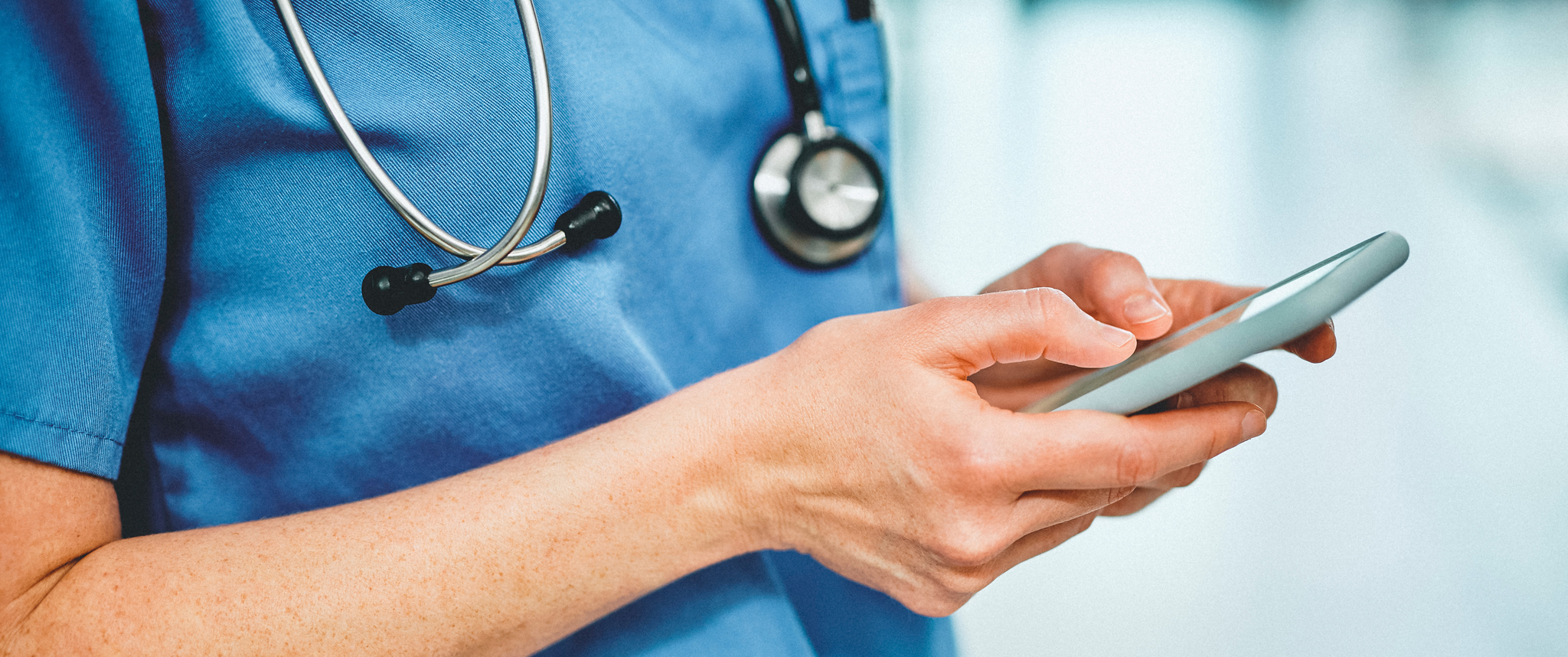 A physician typing on a cellphone