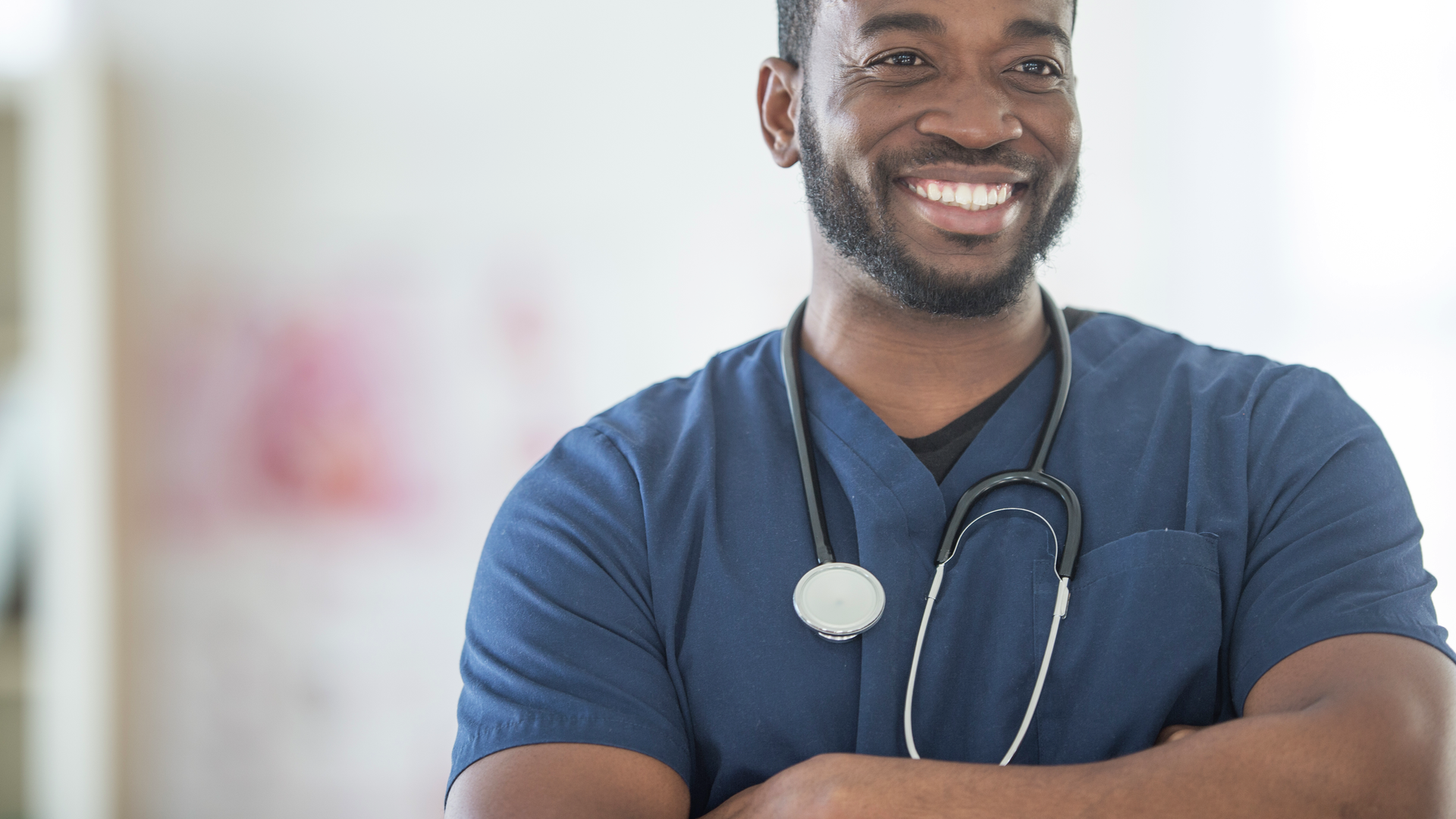 Male nurse smiling with stethoscope around his shoulders