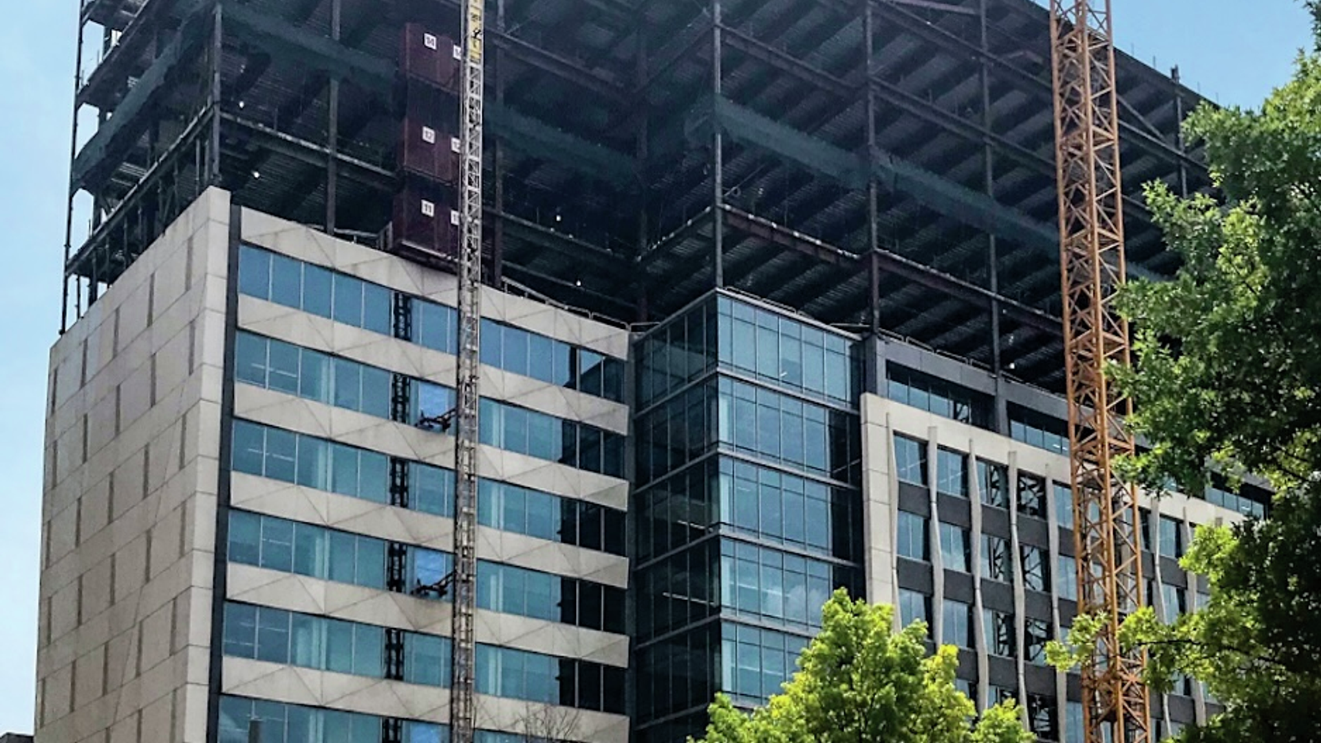 A building under construction with several upper floors showing only the beams framing the new space