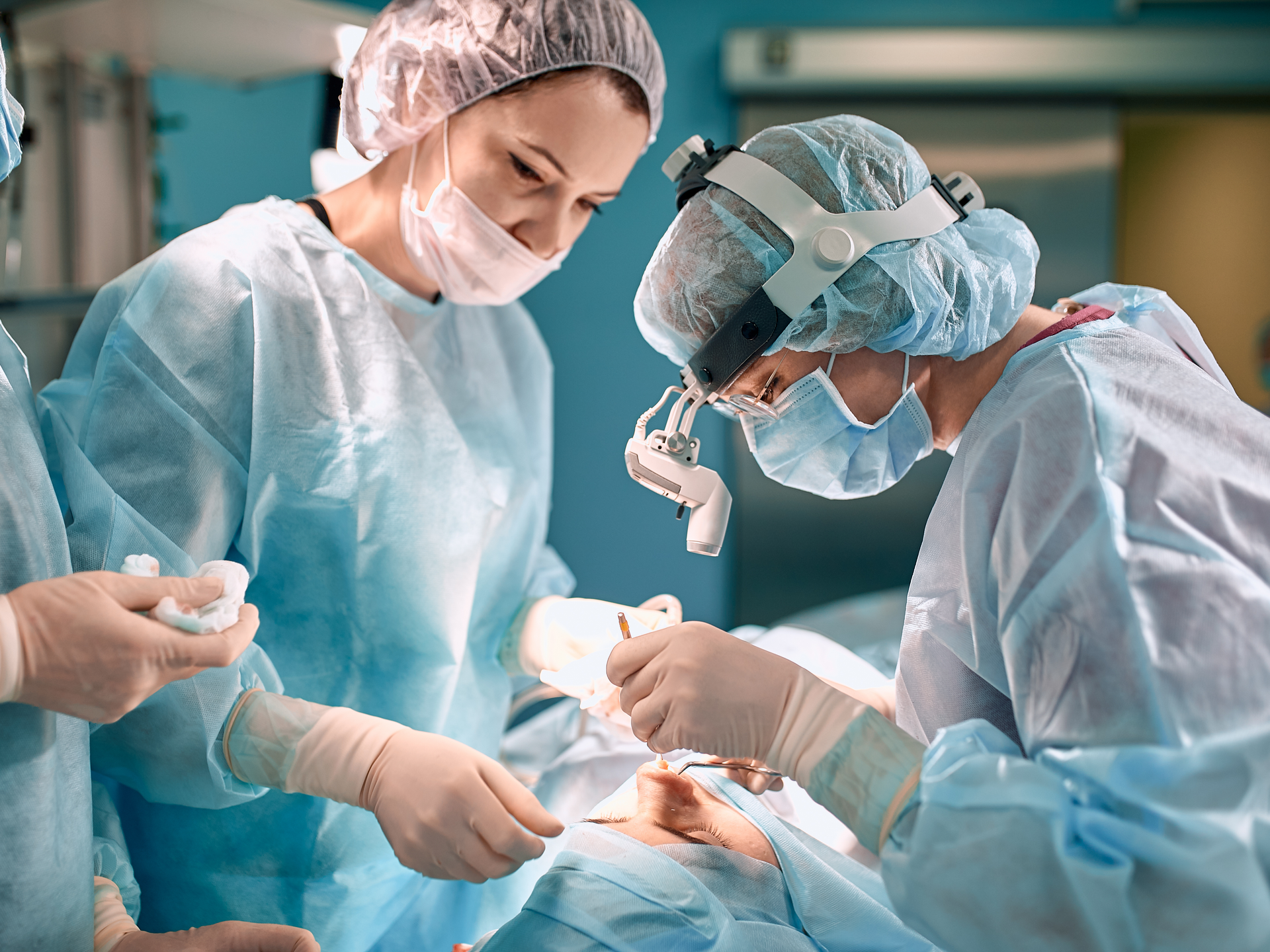 Surgeon with gloves is operating on patients nose