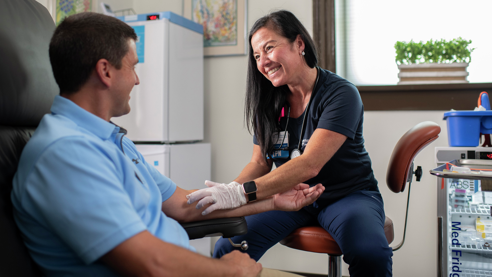 Vita Mazzola smiles interacting with a patient in an exam room