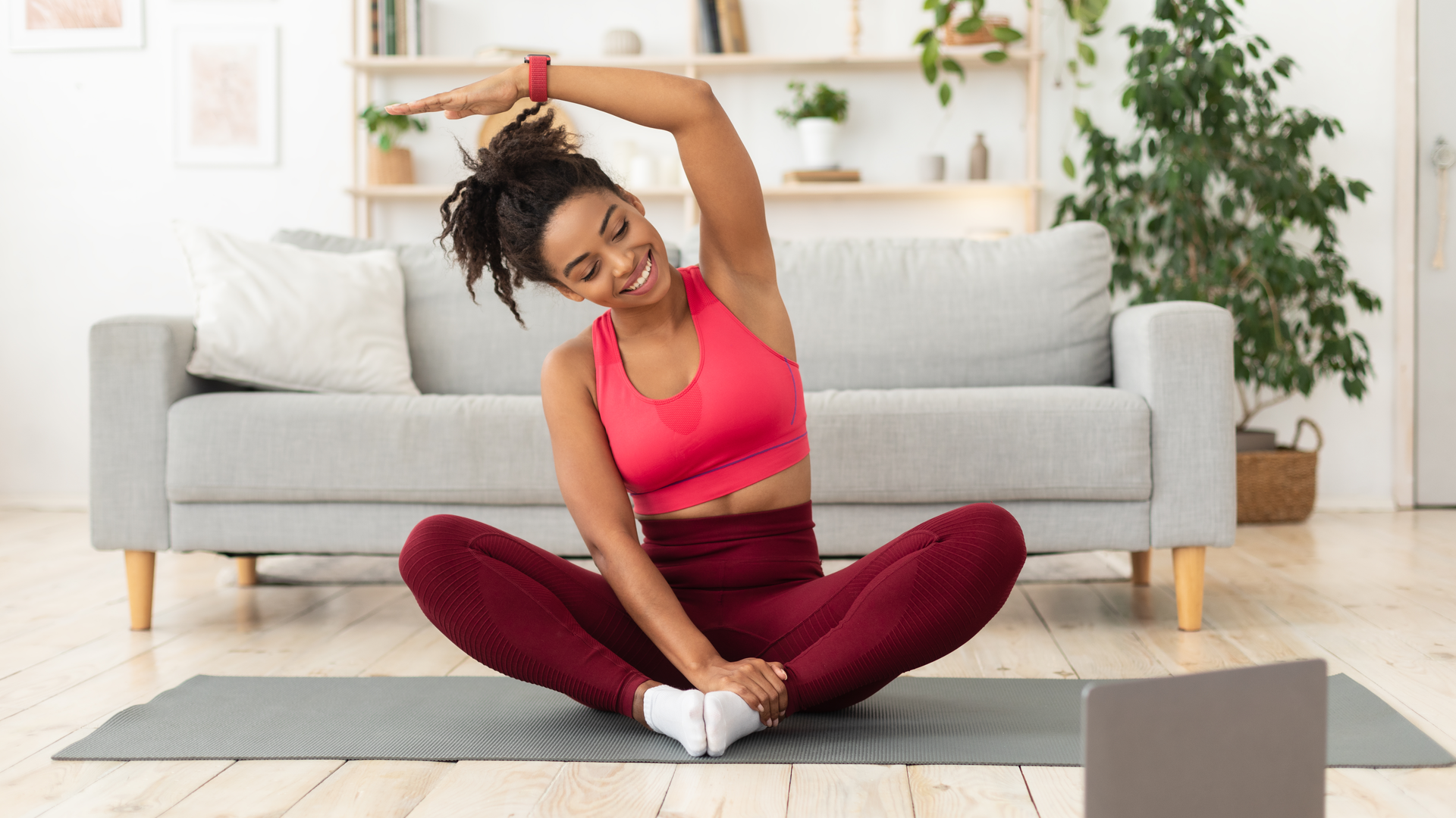 Black woman exercising at laptop having online training at home