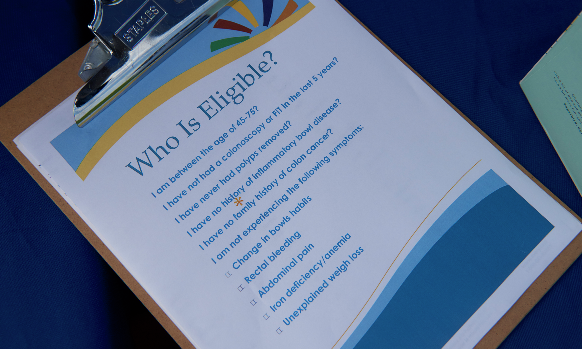 A clipboard with colorful graphics and a list of eligibility criteria for taking a FIT test