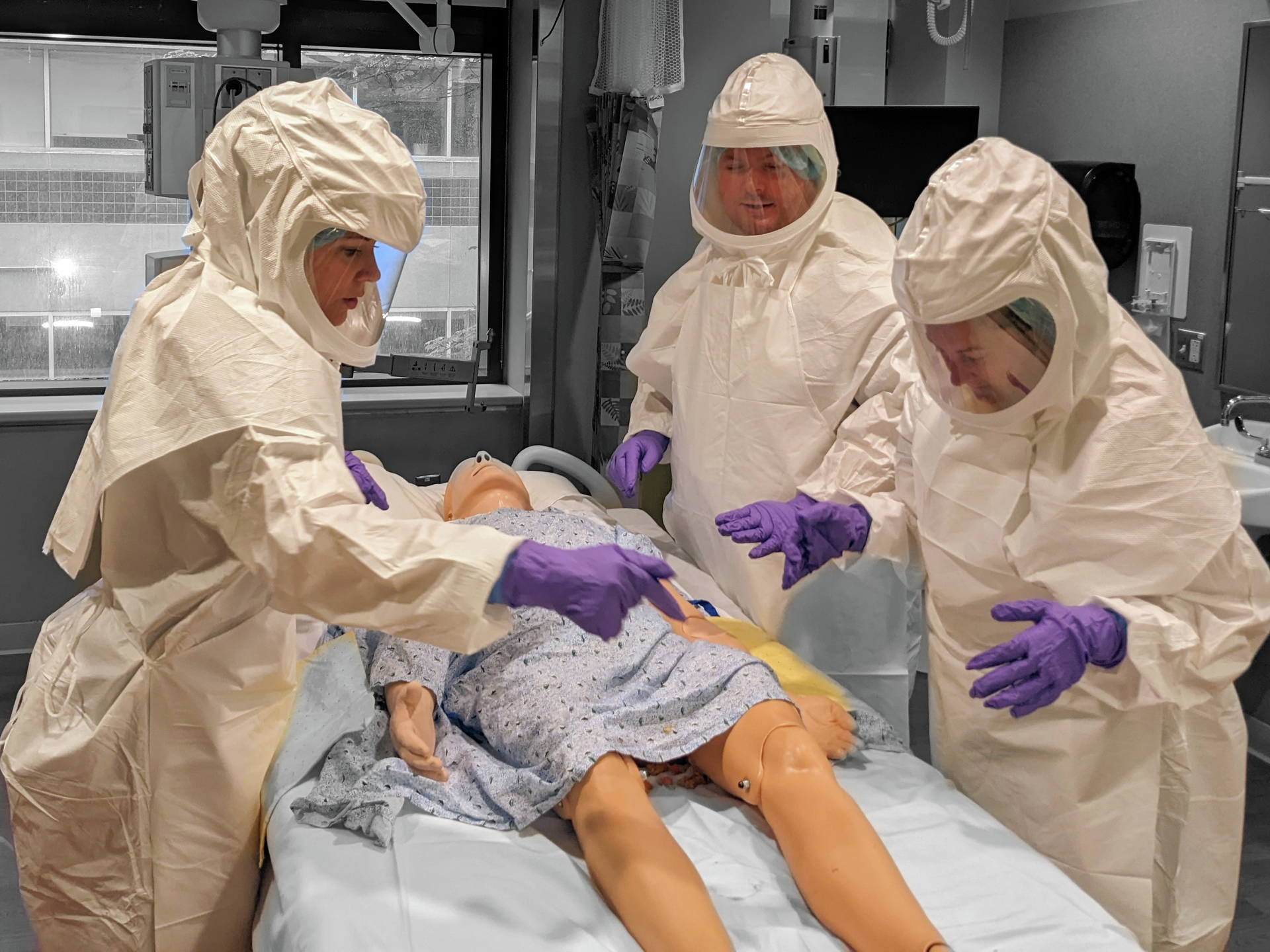 Medical staff simulate treating a patient with an extremely contagious illness during a biohazard training drill
