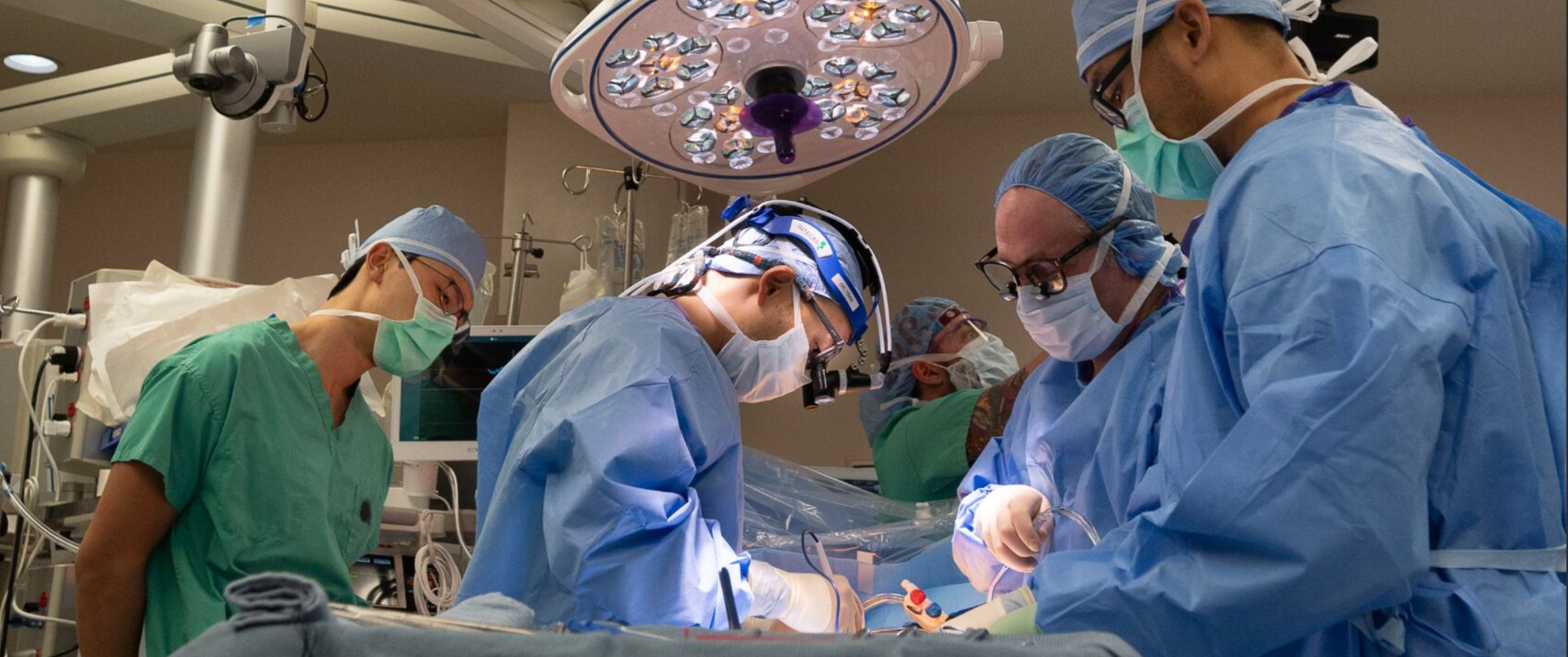  In an operating room, a team of surgeons perform minimally invasive heart surgery.