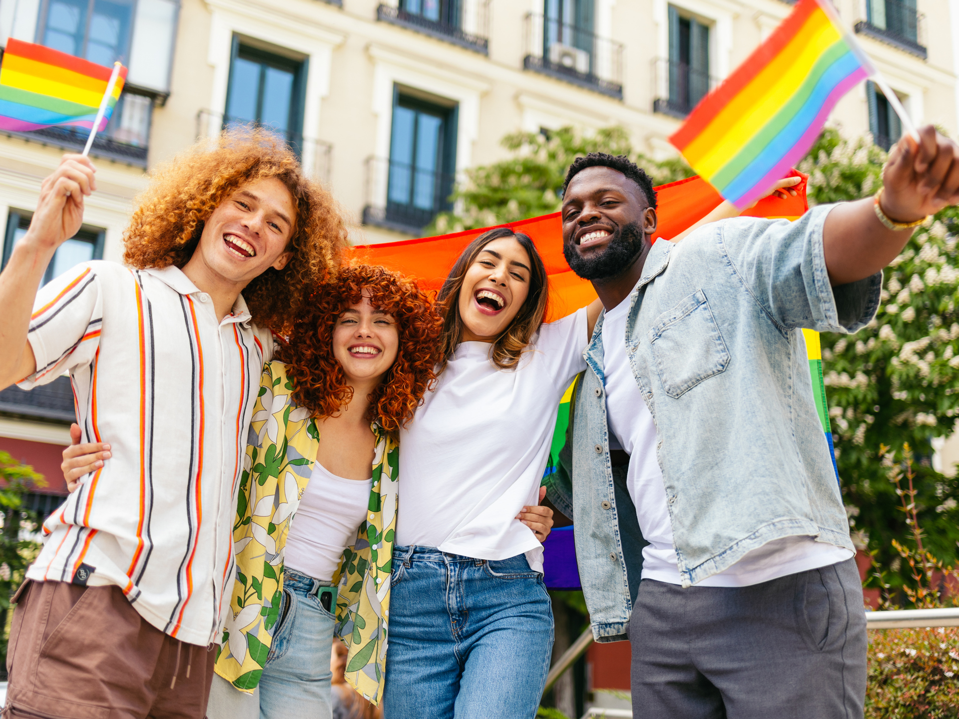 Friends waving rainbow flags while celebrating LGBT pride month
