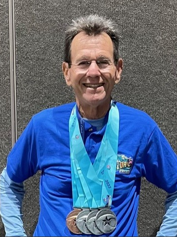 Gary Rosenbaum wearing race medals around his neck